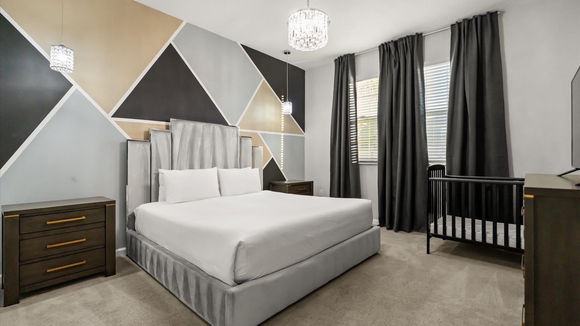 Bedroom 4 – Contemporary king room with geometric wall design and blackout curtains.