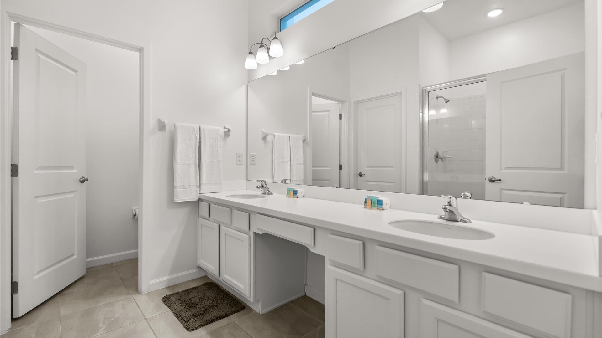 Spacious en-suite bathroom with dual basins and a large standing shower