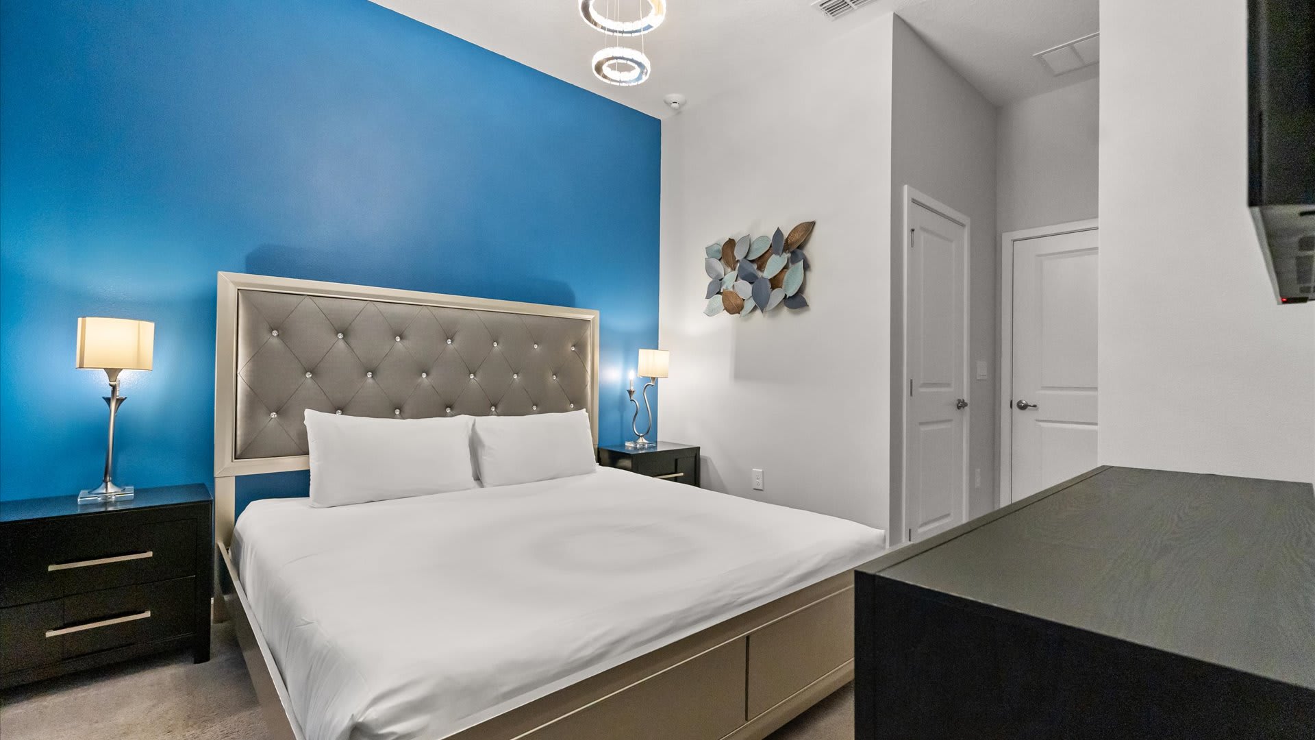 Bedroom 1 – Bright king bedroom with calming blue feature wall and Smart TV.