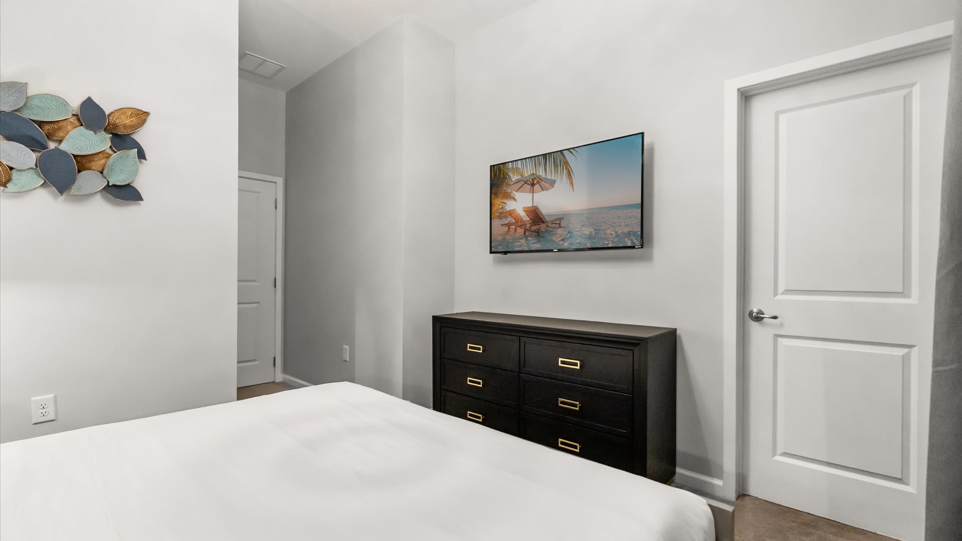 Bedroom 1 – Bright king bedroom with calming blue feature wall and Smart TV.