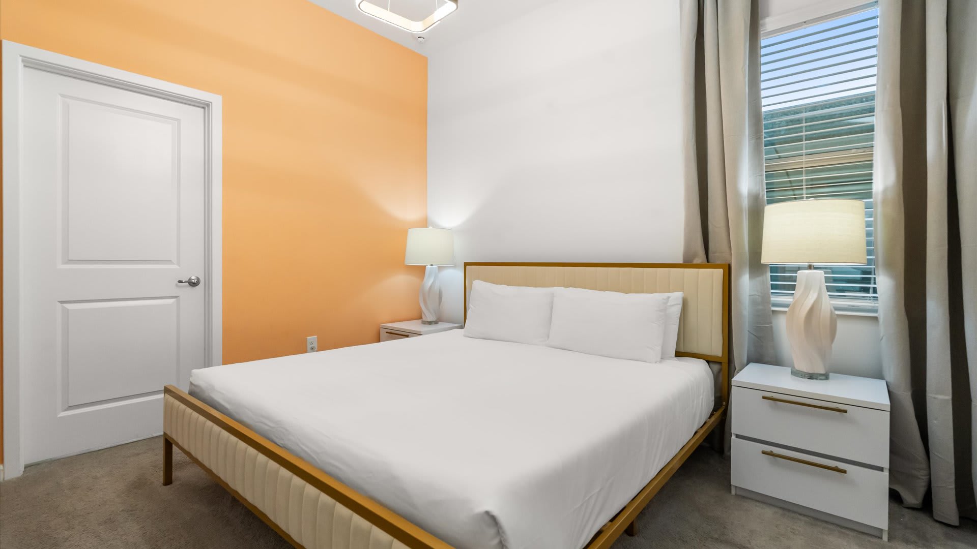 Bedroom 5 – Bright king room with warm orange tones and clean modern décor.