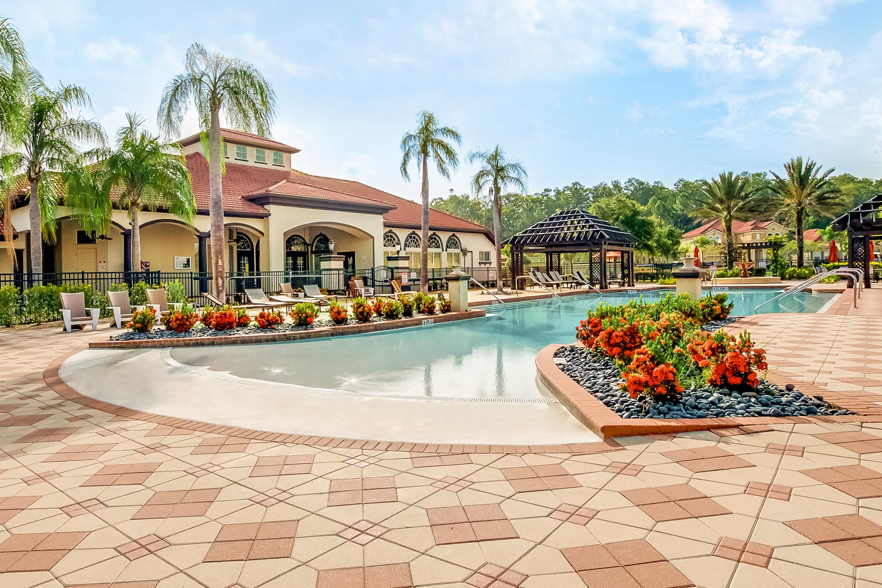 Resort Pool Surrounded By Palm Trees And Relaxing Loungers