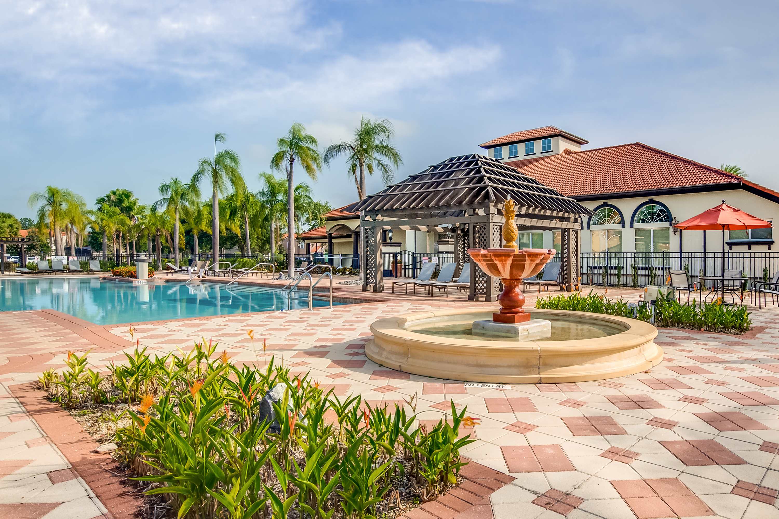 Resort Pool Surrounded By Palm Trees And Relaxing Loungers
