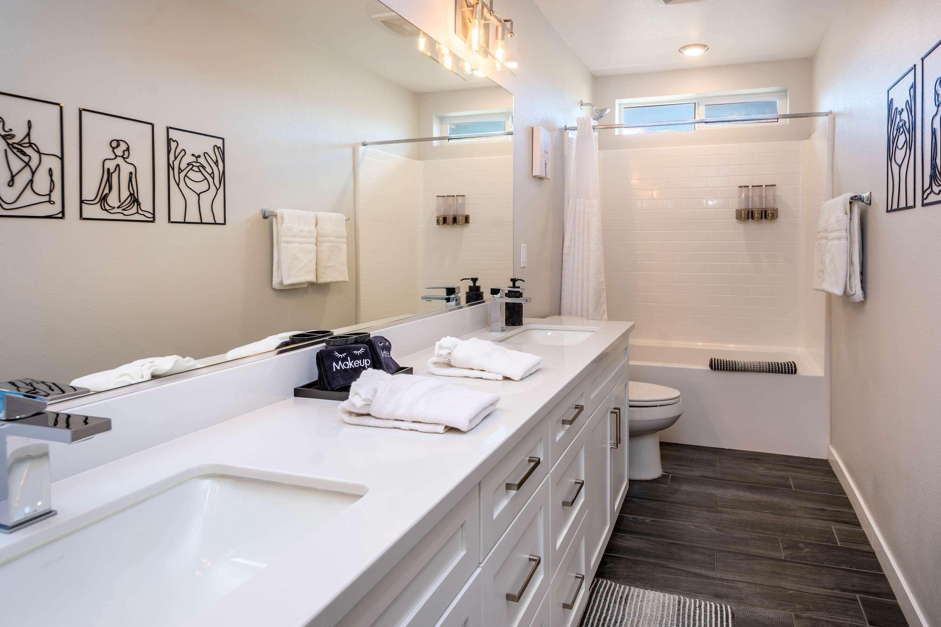 Hallway full sized bathroom with dual vanity
