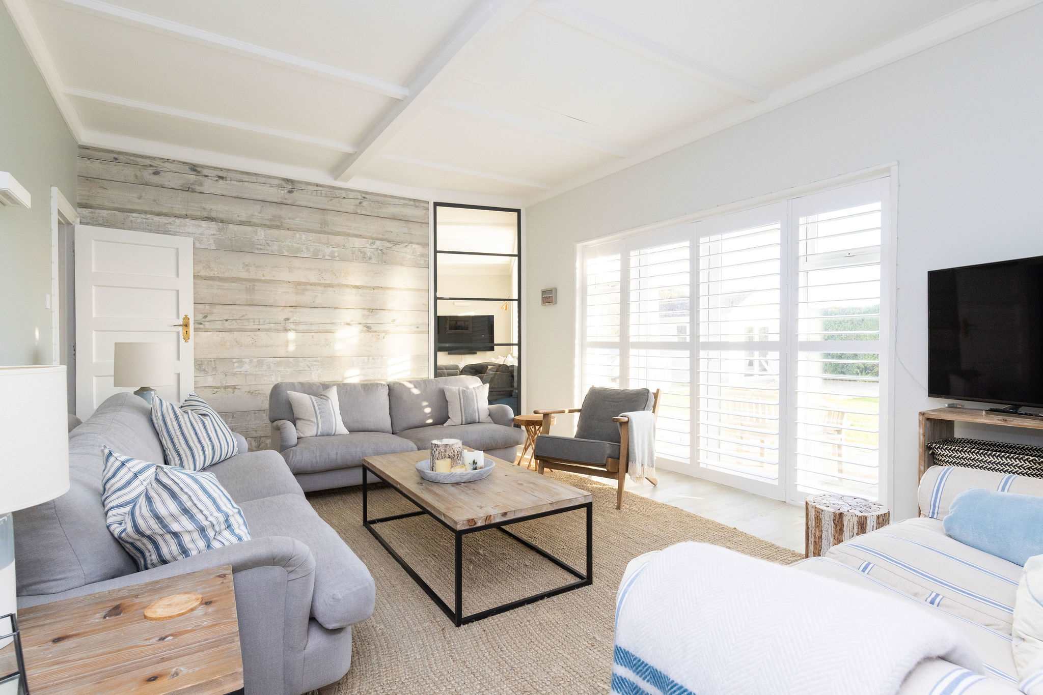 Sun-filled living area with garden access & TV.