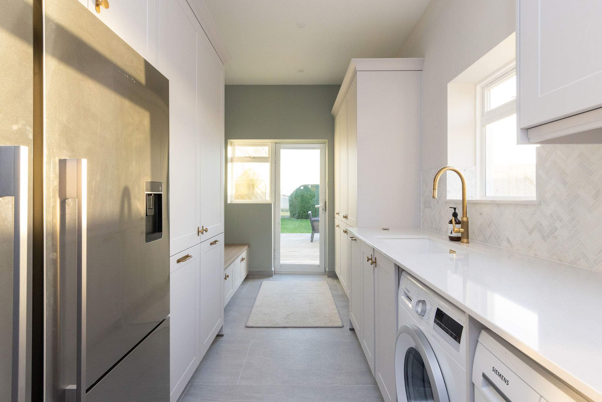 A large connecting utility room with further countertop space, storage and amenities.