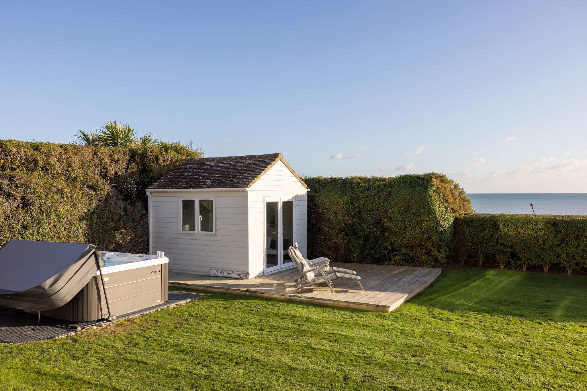 Seafront garden with hot tub & sun deck.