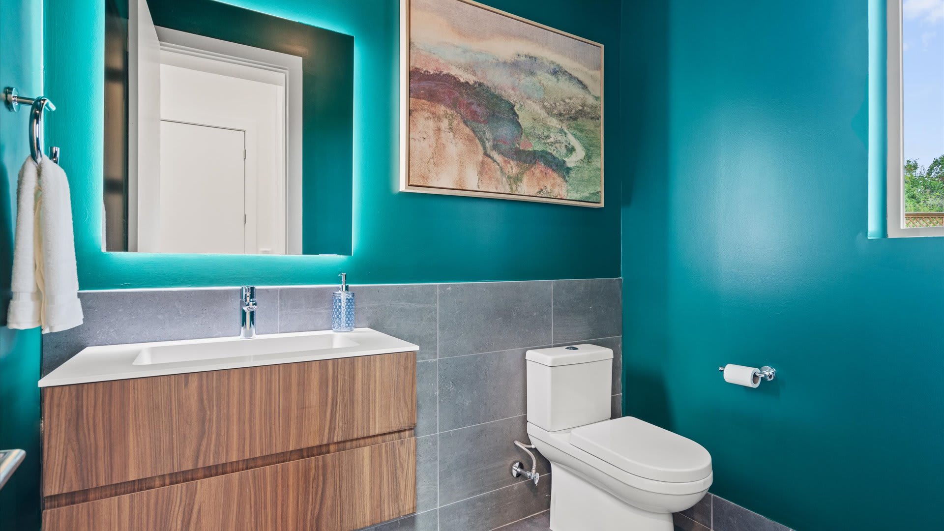 Vibrant teal bathroom with sleek finishes