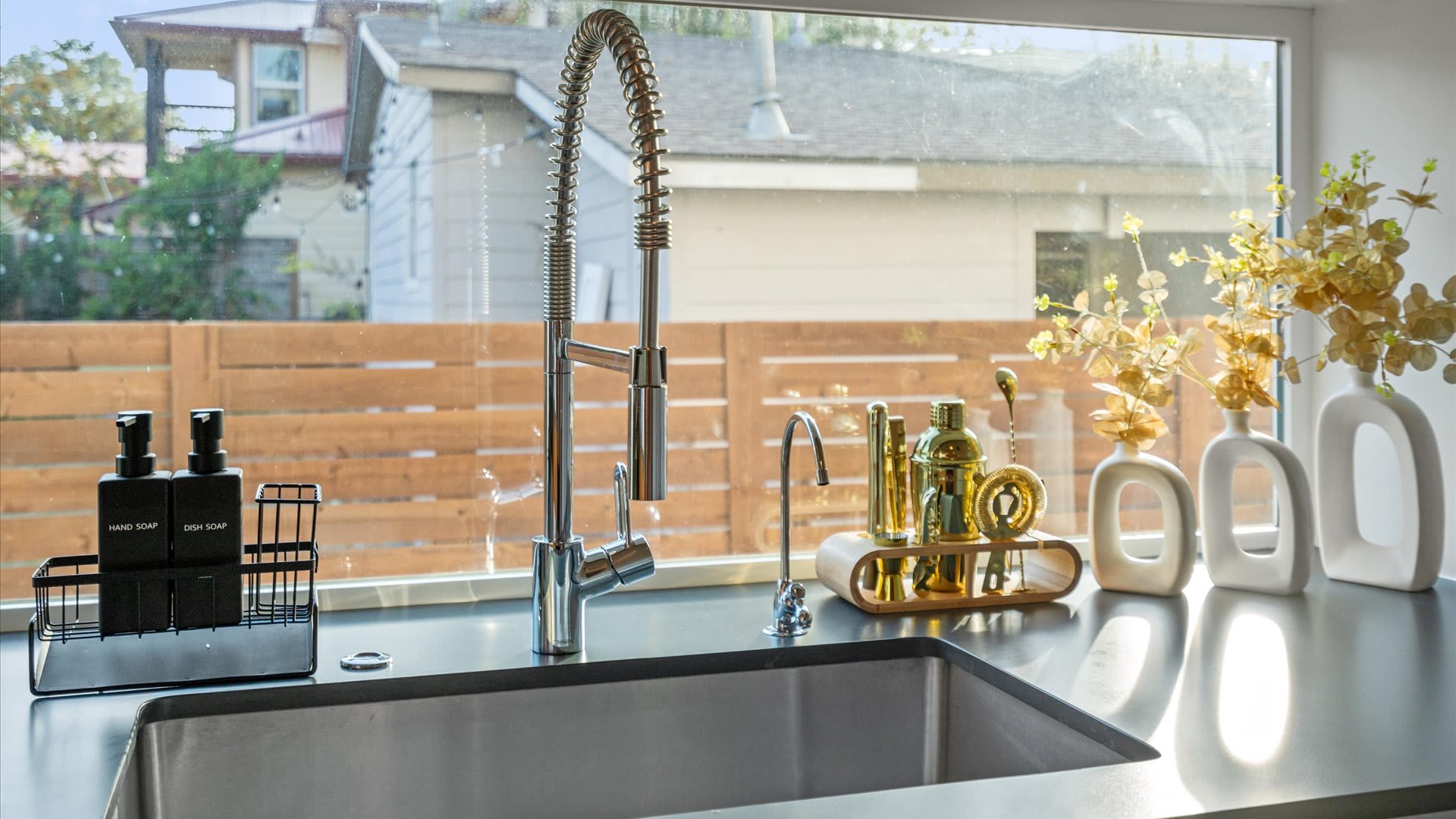 Modern sink with filtered water tap and backyard views