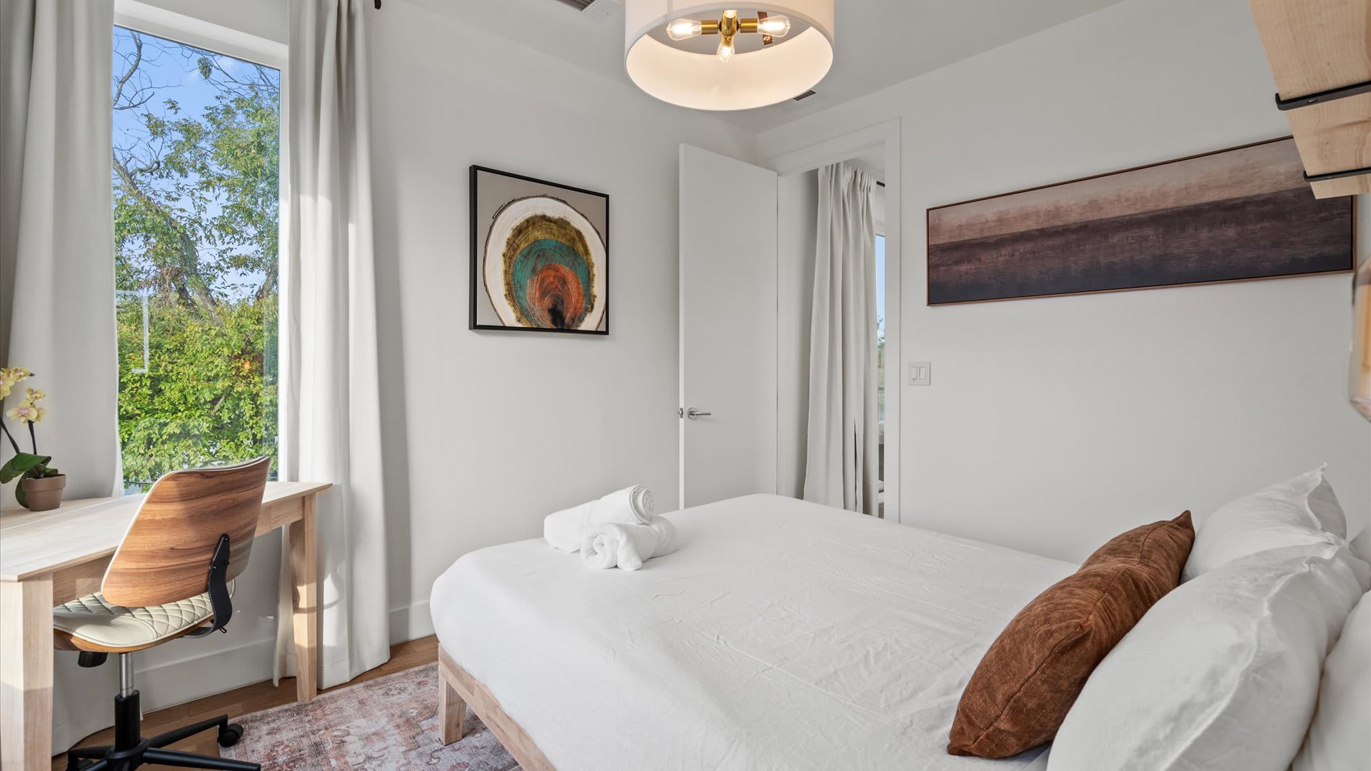 Stylish bedroom with curated artwork and warm wood details