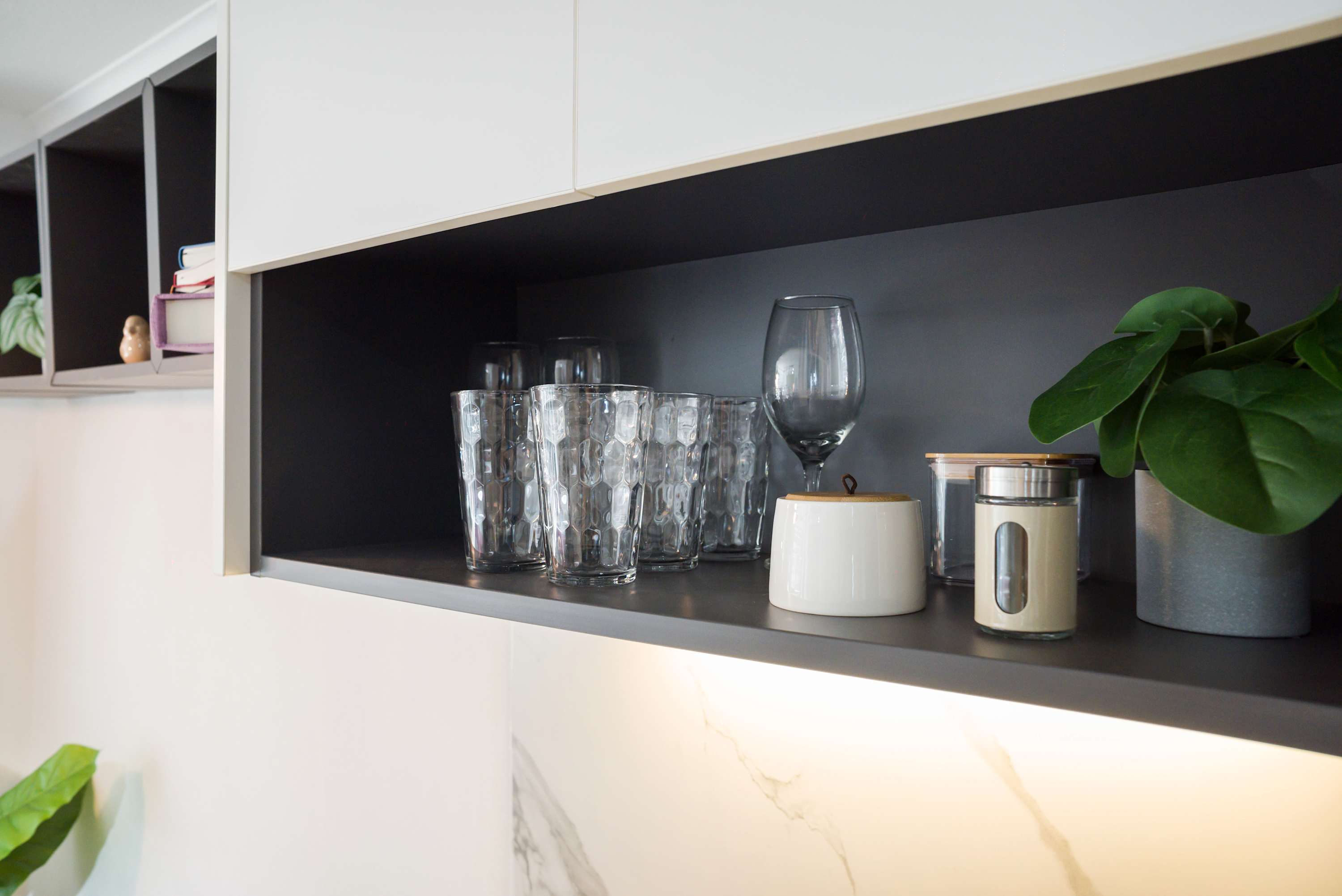 Stylish kitchen shelving with elegant glassware and modern decor, perfect for a cozy stay.