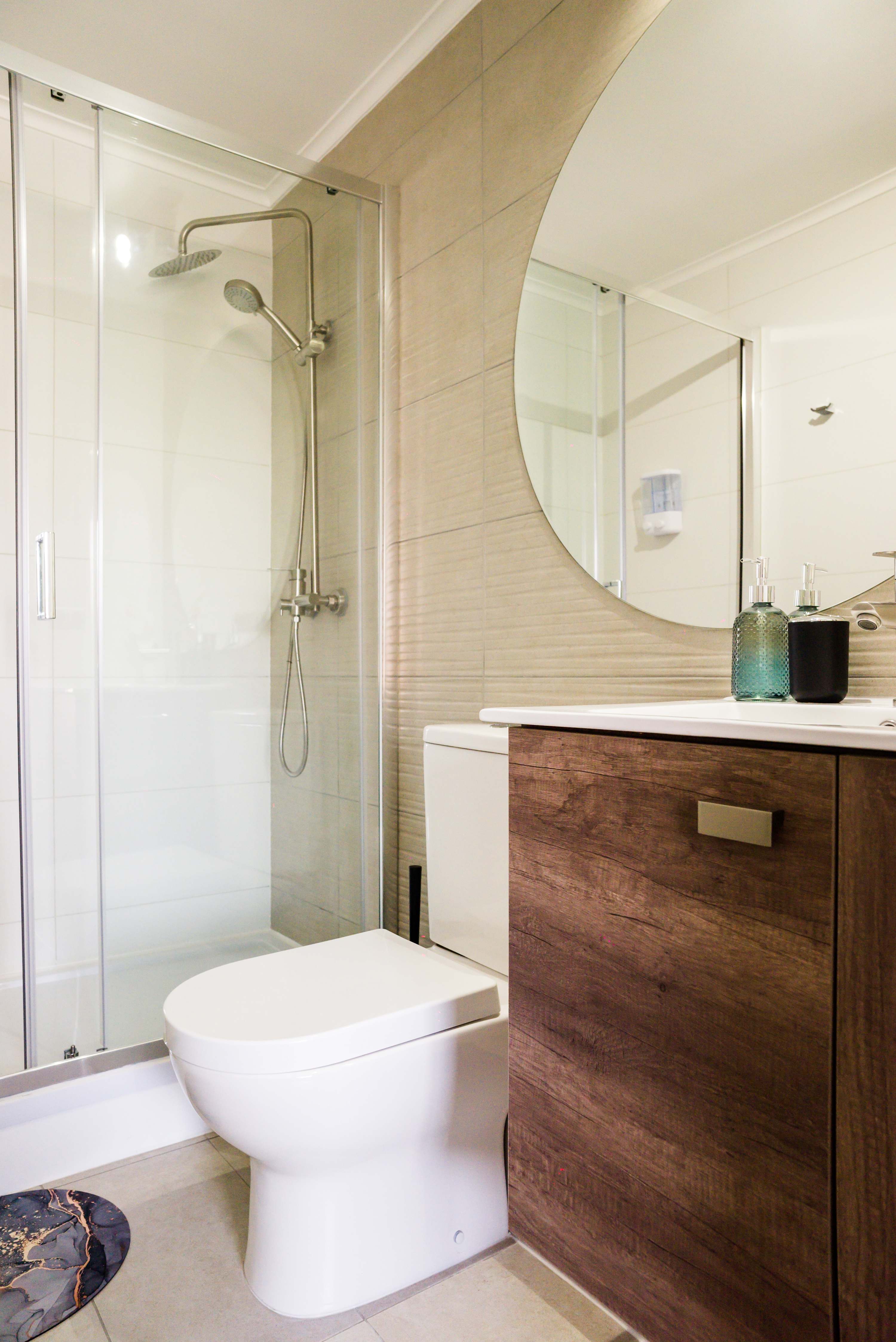 Sleek and modern bathroom with a spacious shower and elegant wood accents, perfect for a refreshing start to your day.
