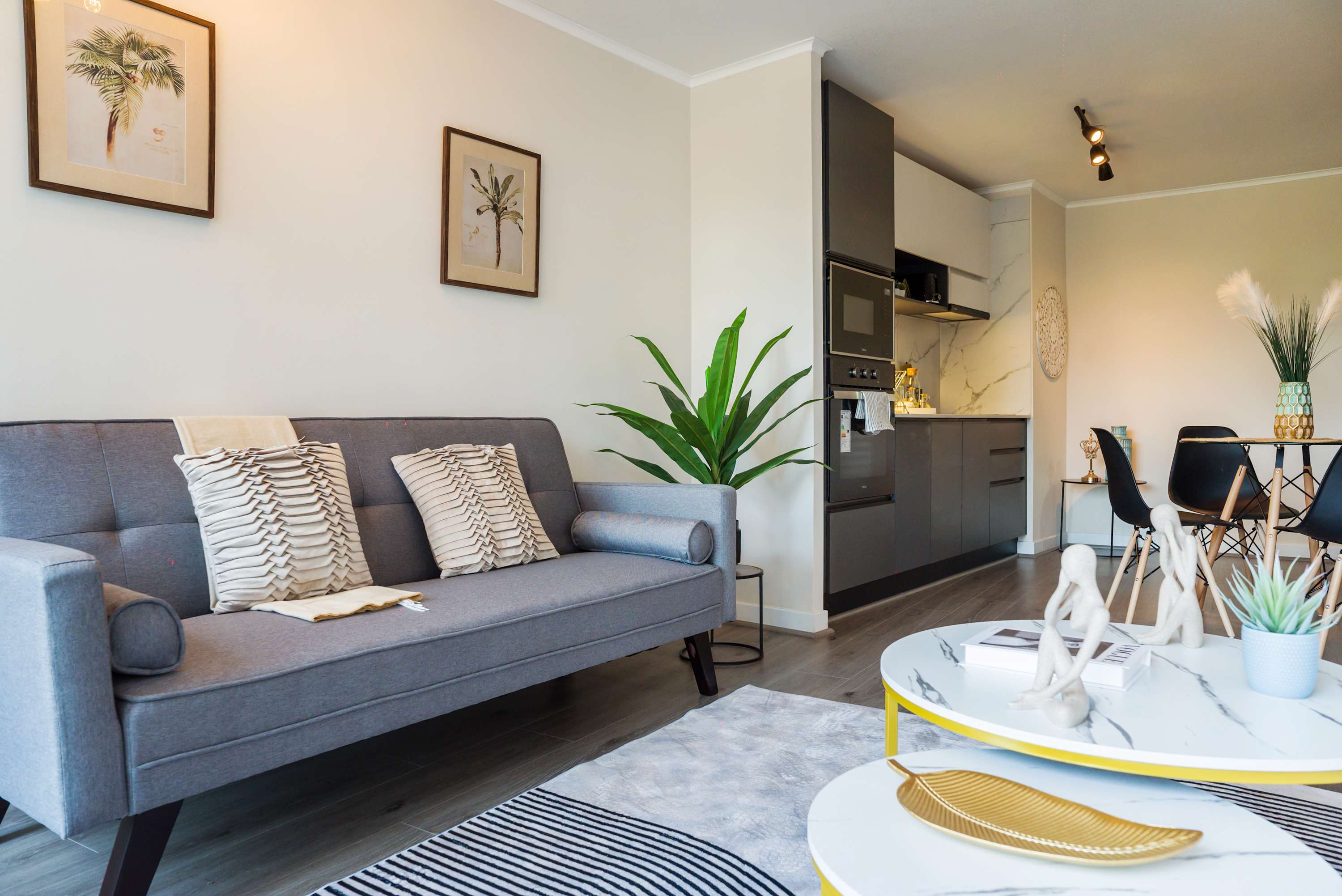 Stylish and cozy living area with modern decor and a compact kitchen, perfect for relaxing and dining in comfort.