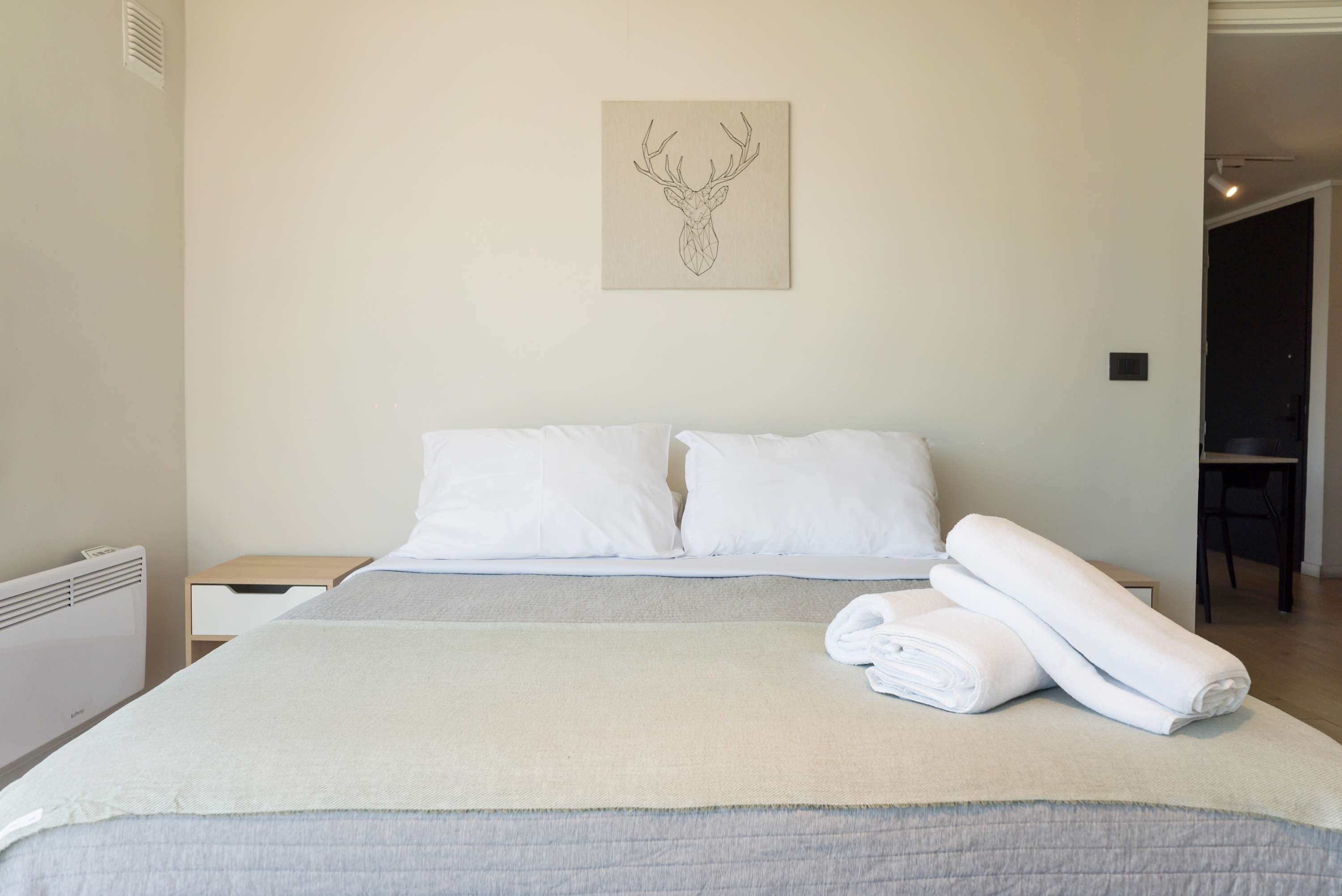 Unwind in this serene bedroom with cozy linens and minimalist decor, perfect for a peaceful retreat.