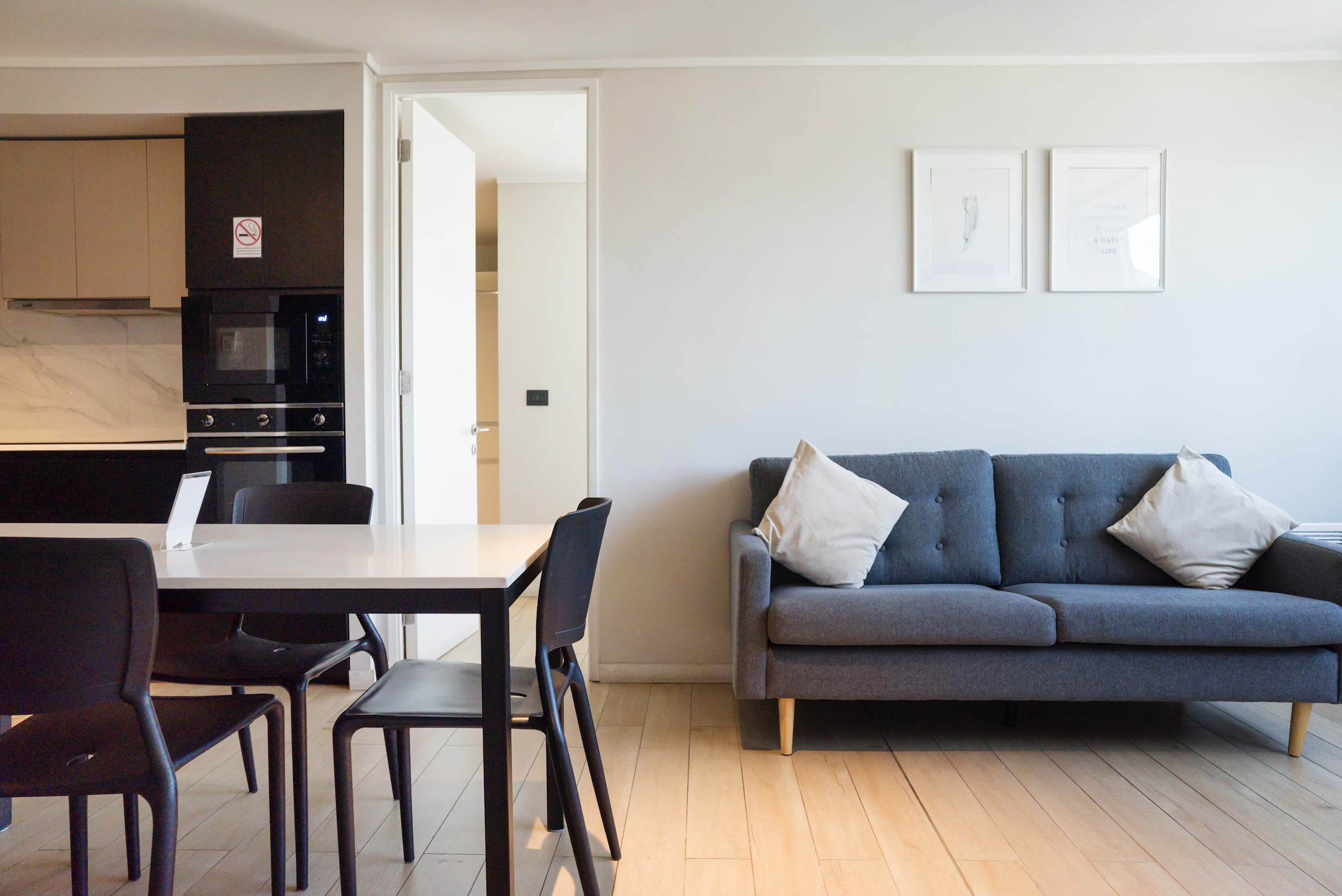 Modern living area with sleek kitchen and cozy seating, perfect for dining and relaxation.