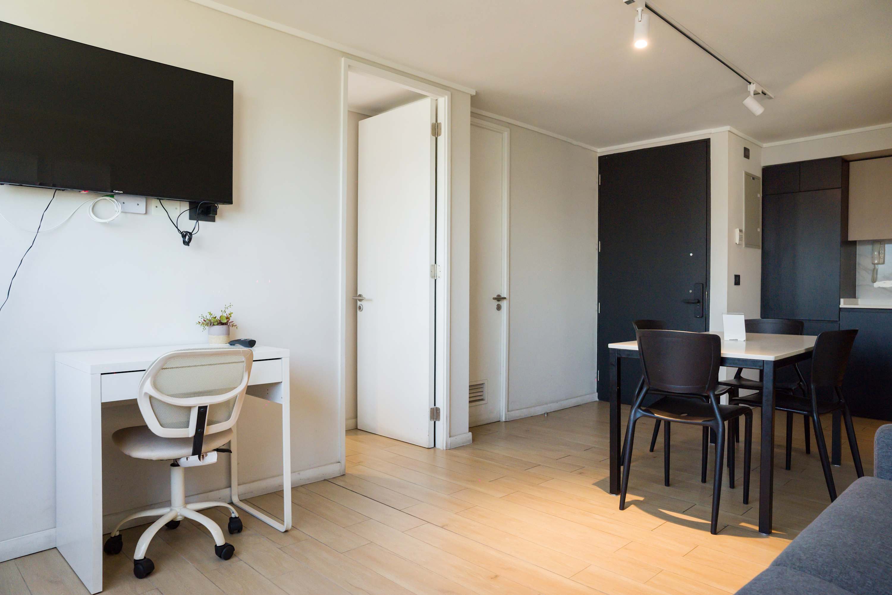 Modern living area with workspace and dining table, ideal for both relaxation and remote work.