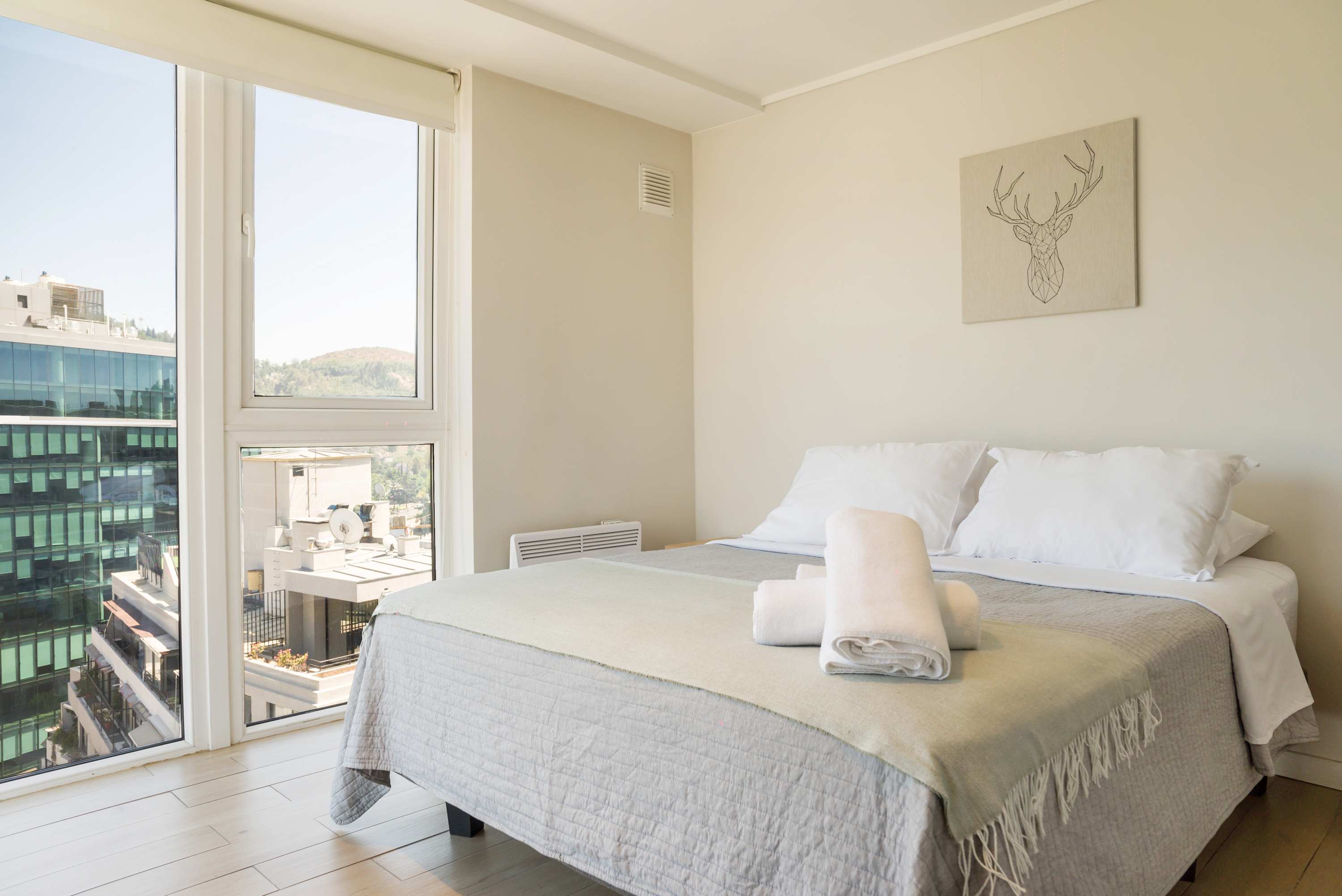 Relax in this cozy bedroom with breathtaking city views, perfect for unwinding after a day of exploring.