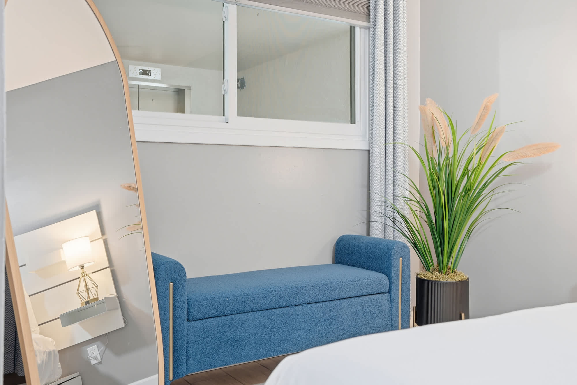 The Summit 1217 – Interior view of a vacation rental with a blue bench, mirror, and potted plant.