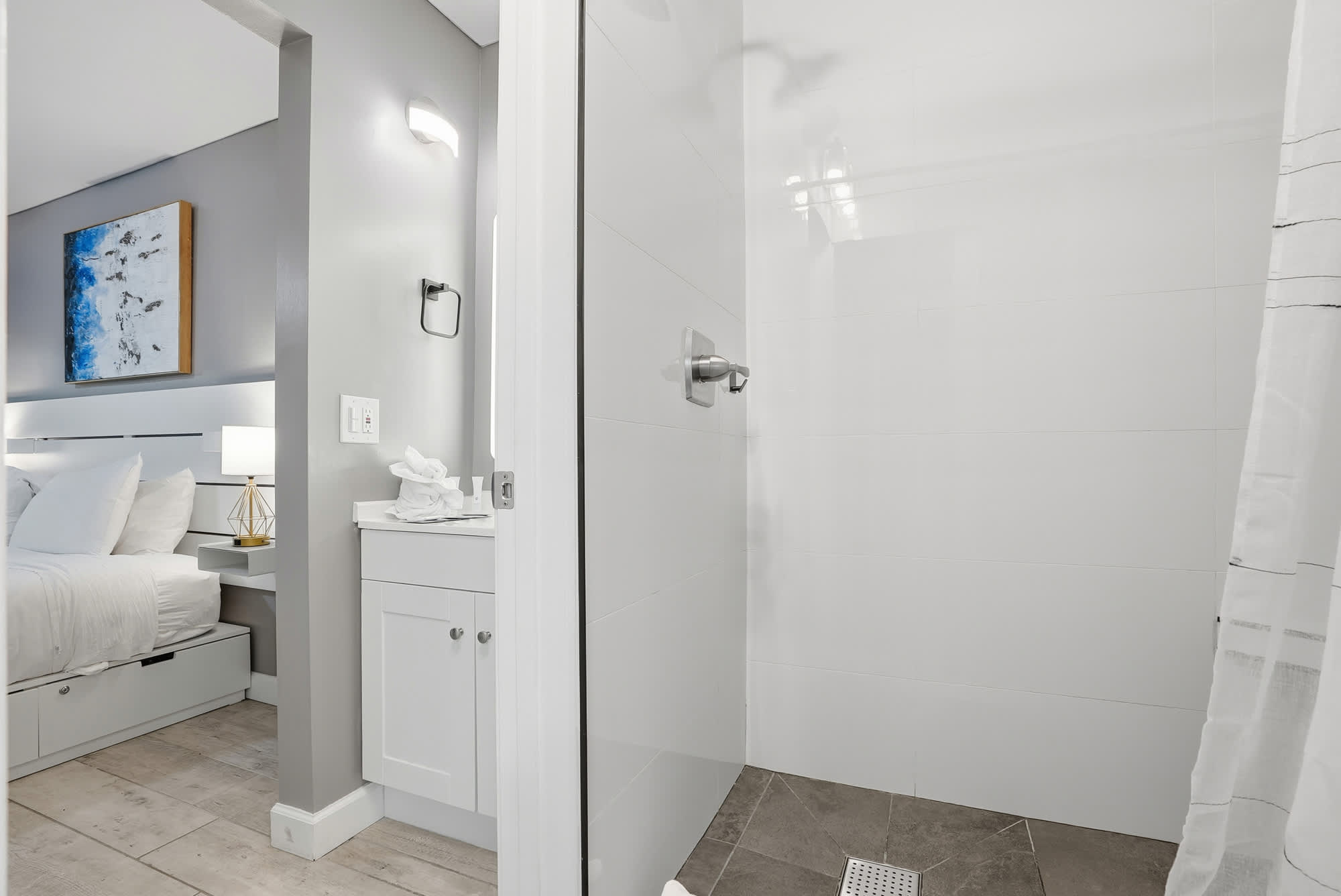 The Summit 1217 – Modern bathroom with shower, bedroom visible with double bed and decorative artwork.