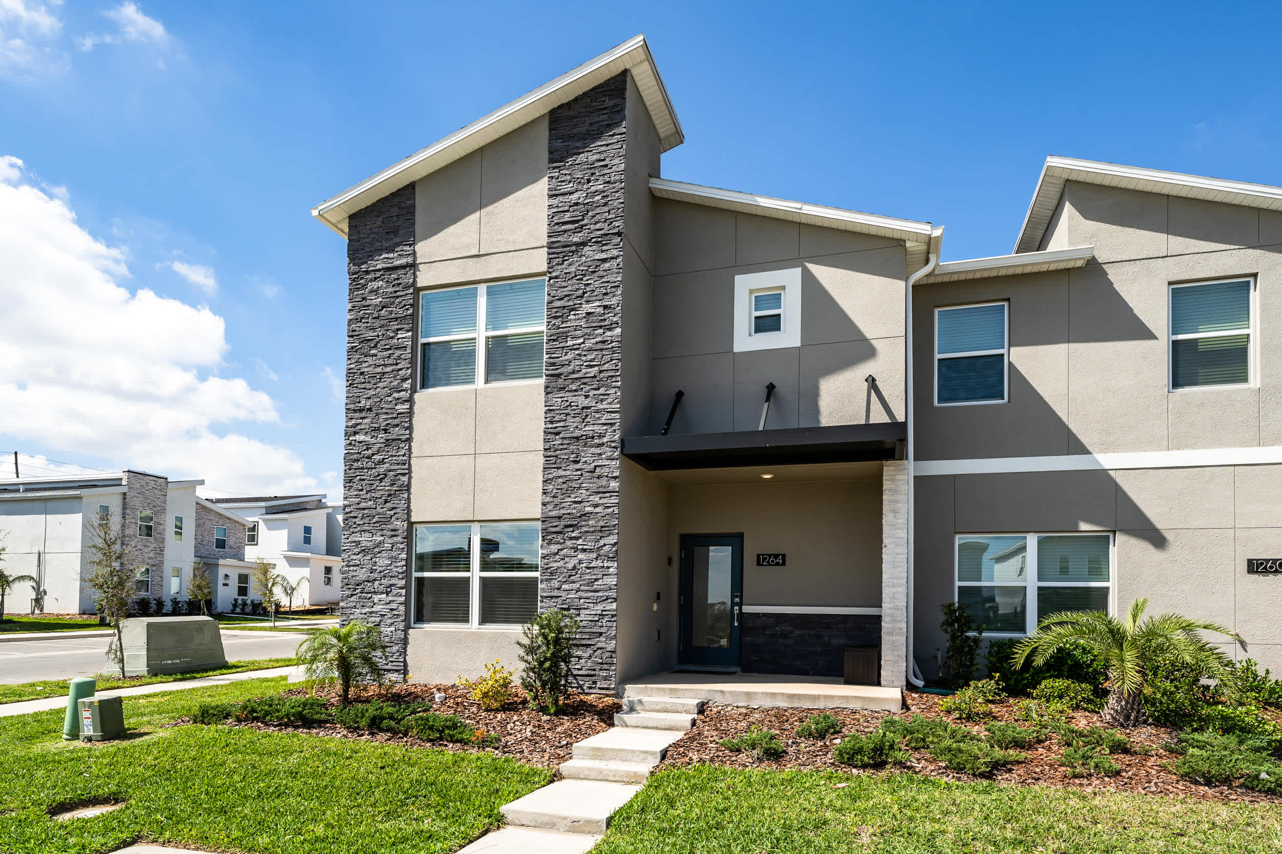 Modern villa with stylish facade and lush landscaping, perfect for a relaxing getaway.
