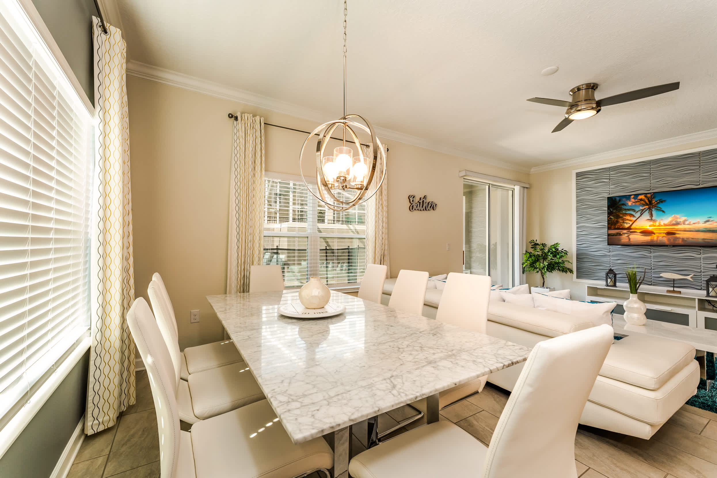 Elegant dining area with a marble table and chic chandelier, perfect for family gatherings.