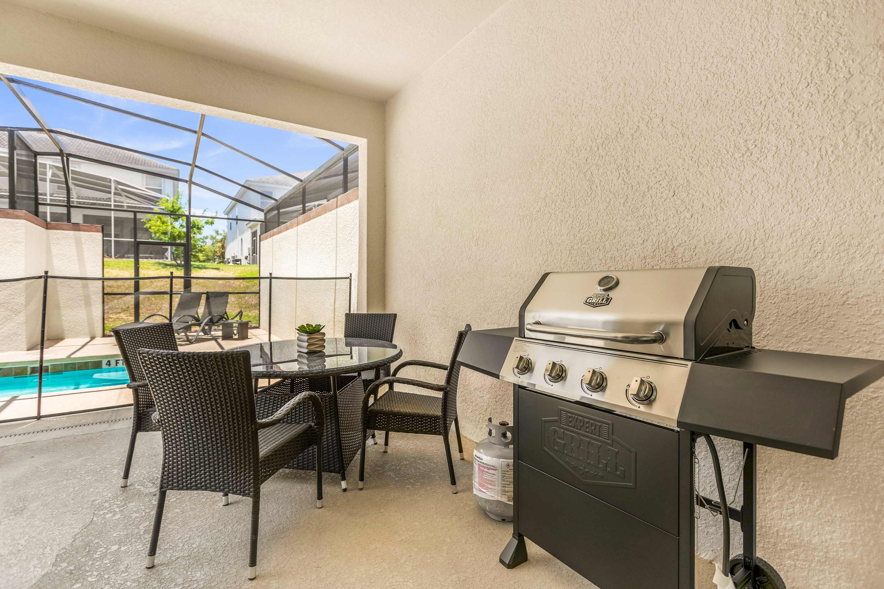 Enjoy outdoor dining and grilling on this private patio with pool views, perfect for family gatherings.
