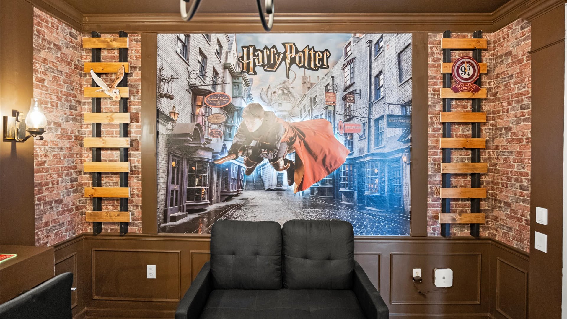 Rustic Hogwarts Game & Media Lounge – Brick walls, dual TVs, and comfy seating create the perfect hangout zone.