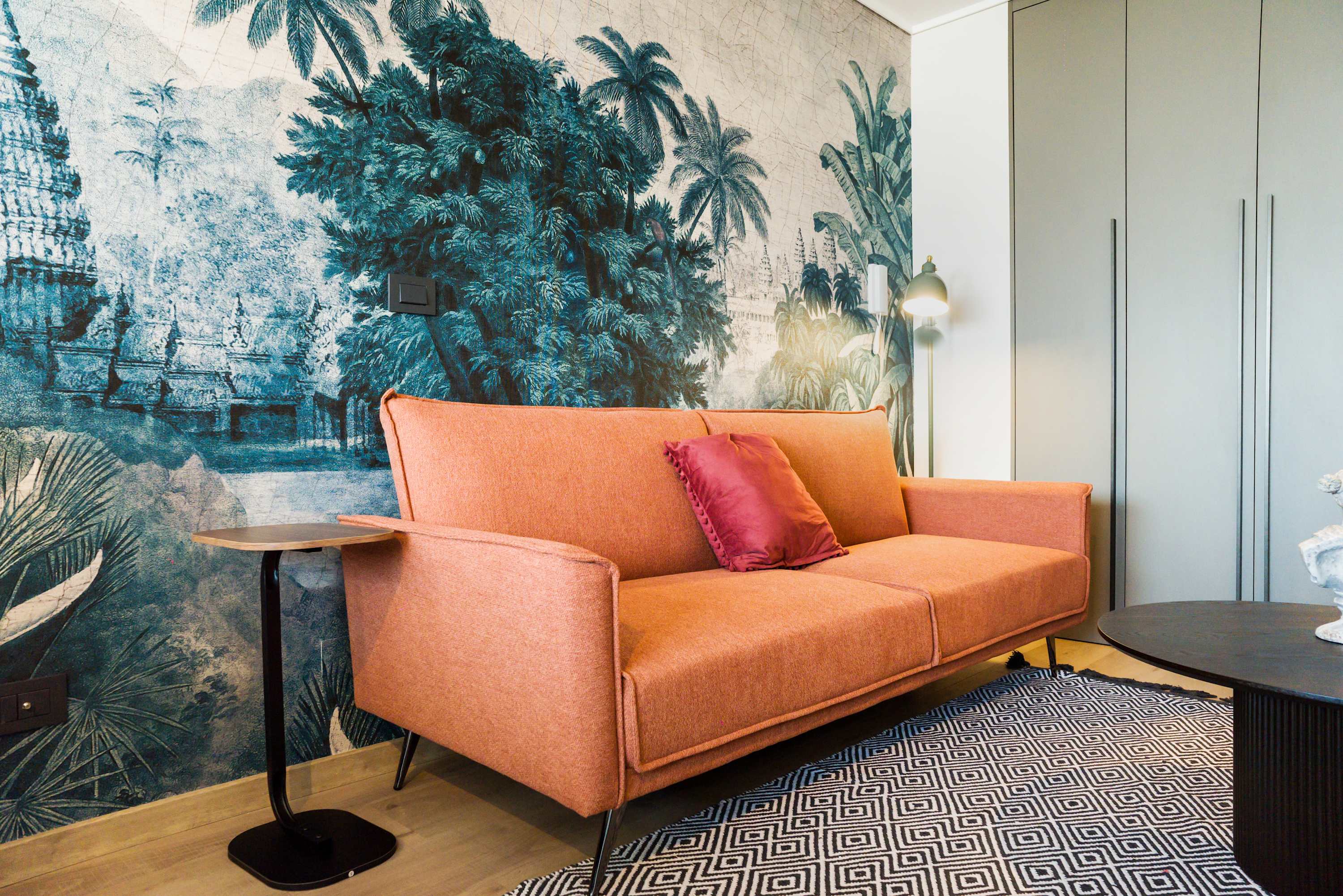 Relax in style with this vibrant living area featuring a bold mural and cozy seating, perfect for unwinding after exploring the city.