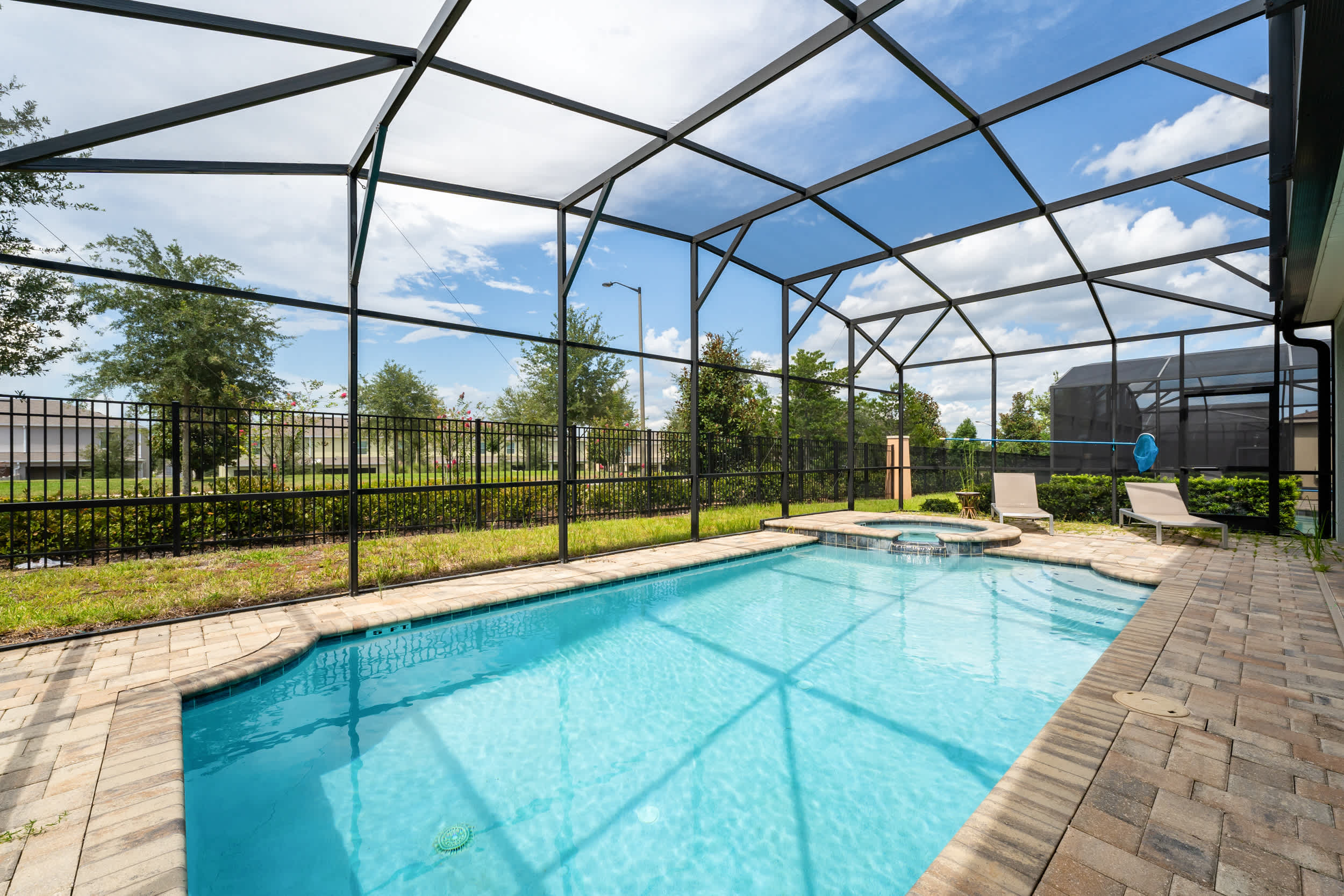 Enjoy a refreshing dip in your private screened-in pool and hot tub, perfect for relaxation and fun.