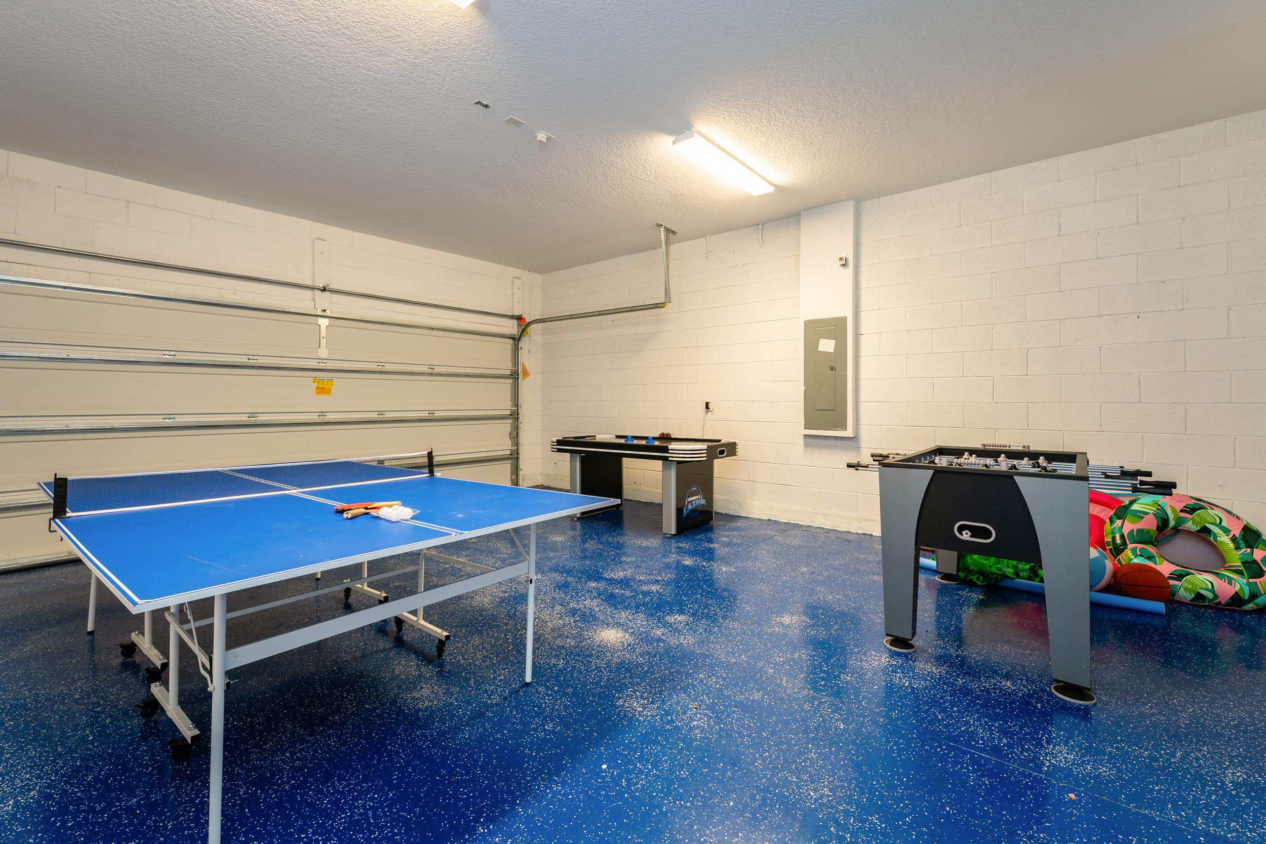 Unleash your competitive spirit in this vibrant game room with ping pong, air hockey, and foosball tables. Perfect for family fun!