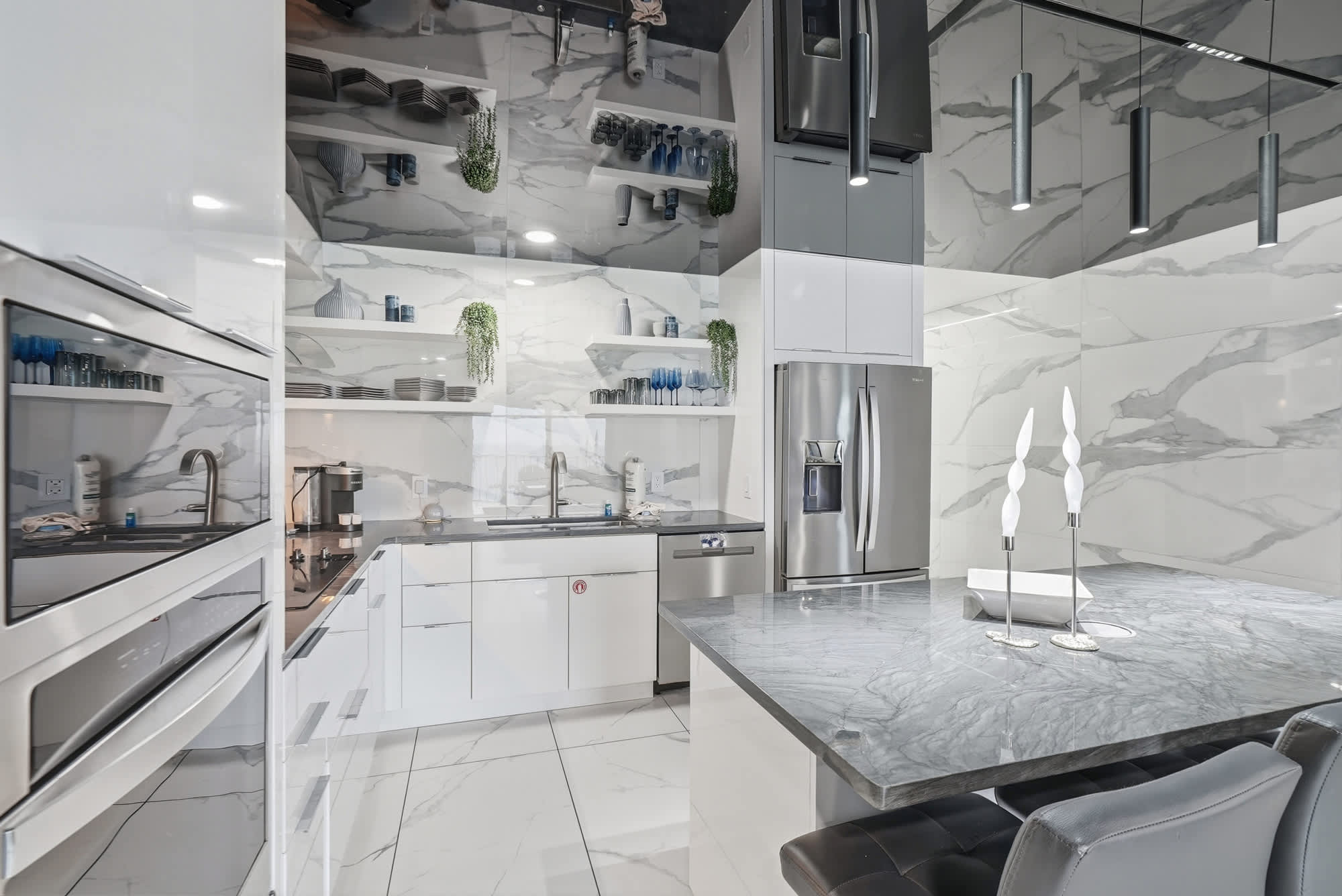 The Summit 1208 – Modern kitchen with marble countertops, stainless steel appliances, and white cabinetry.