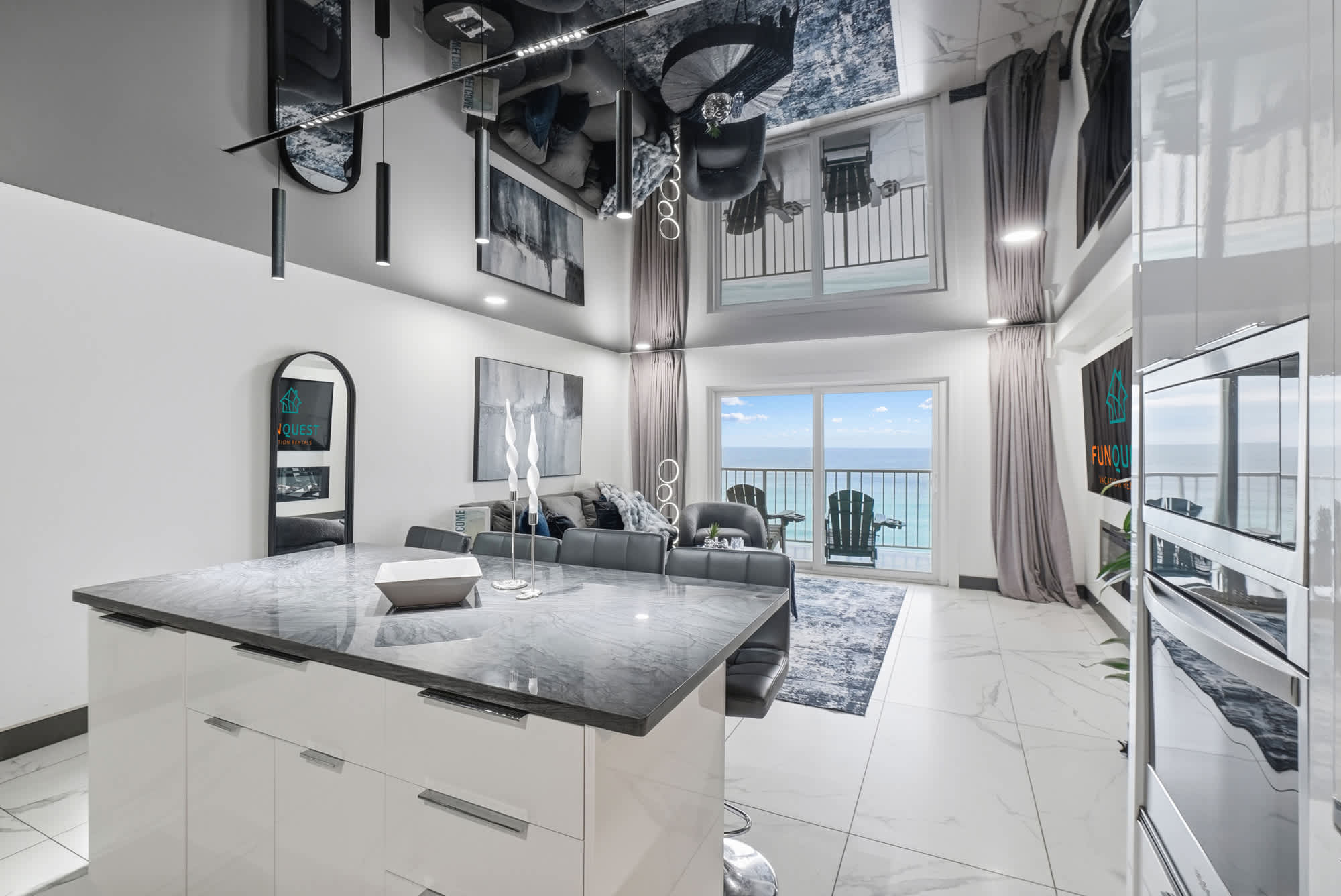 The Summit 1208 – Stylish living room with ocean view, gray furniture, modern decor, and a kitchen island.