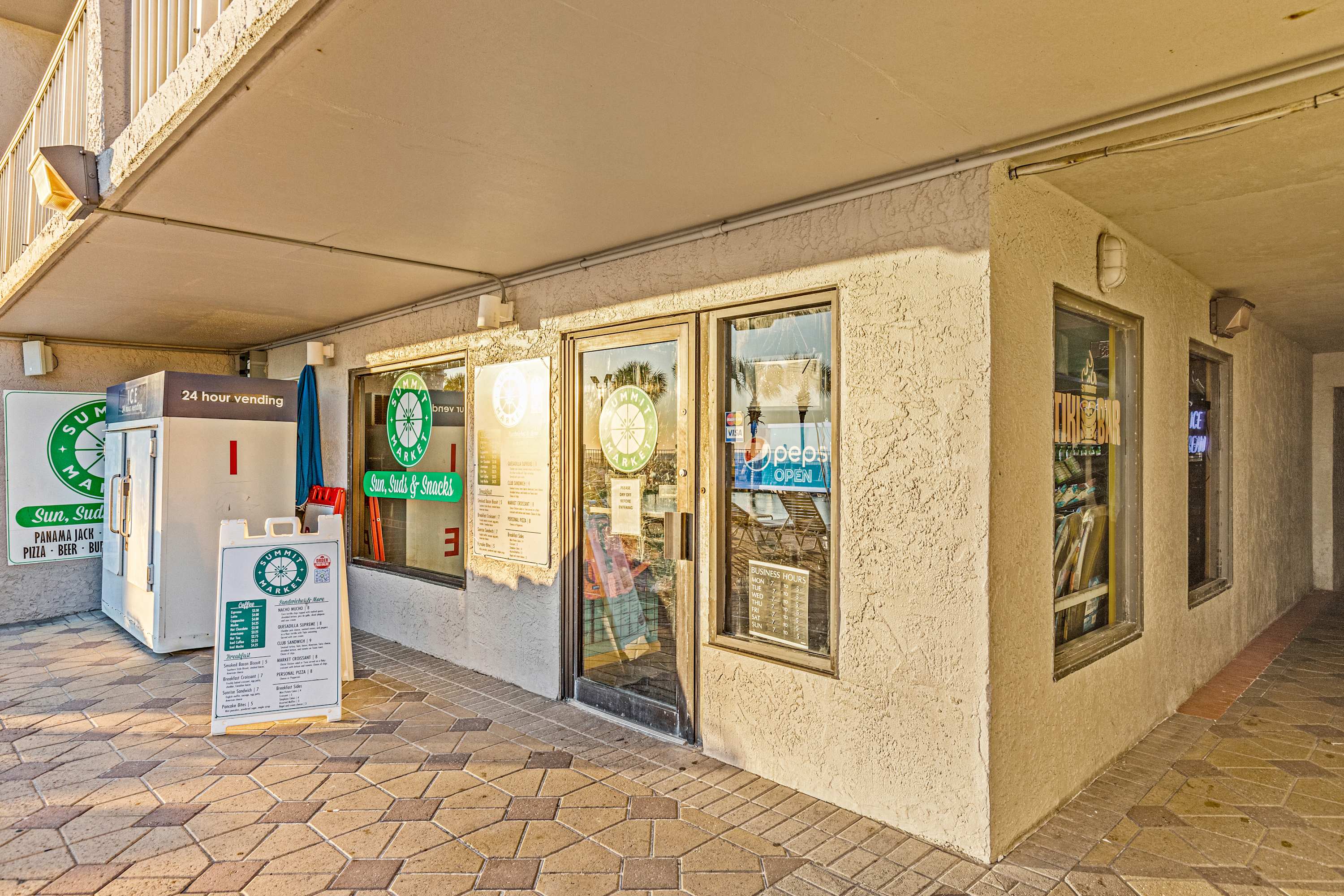 The Summit 1208 – Exterior view of The Summit 1208 market with vending machine and menu signage.