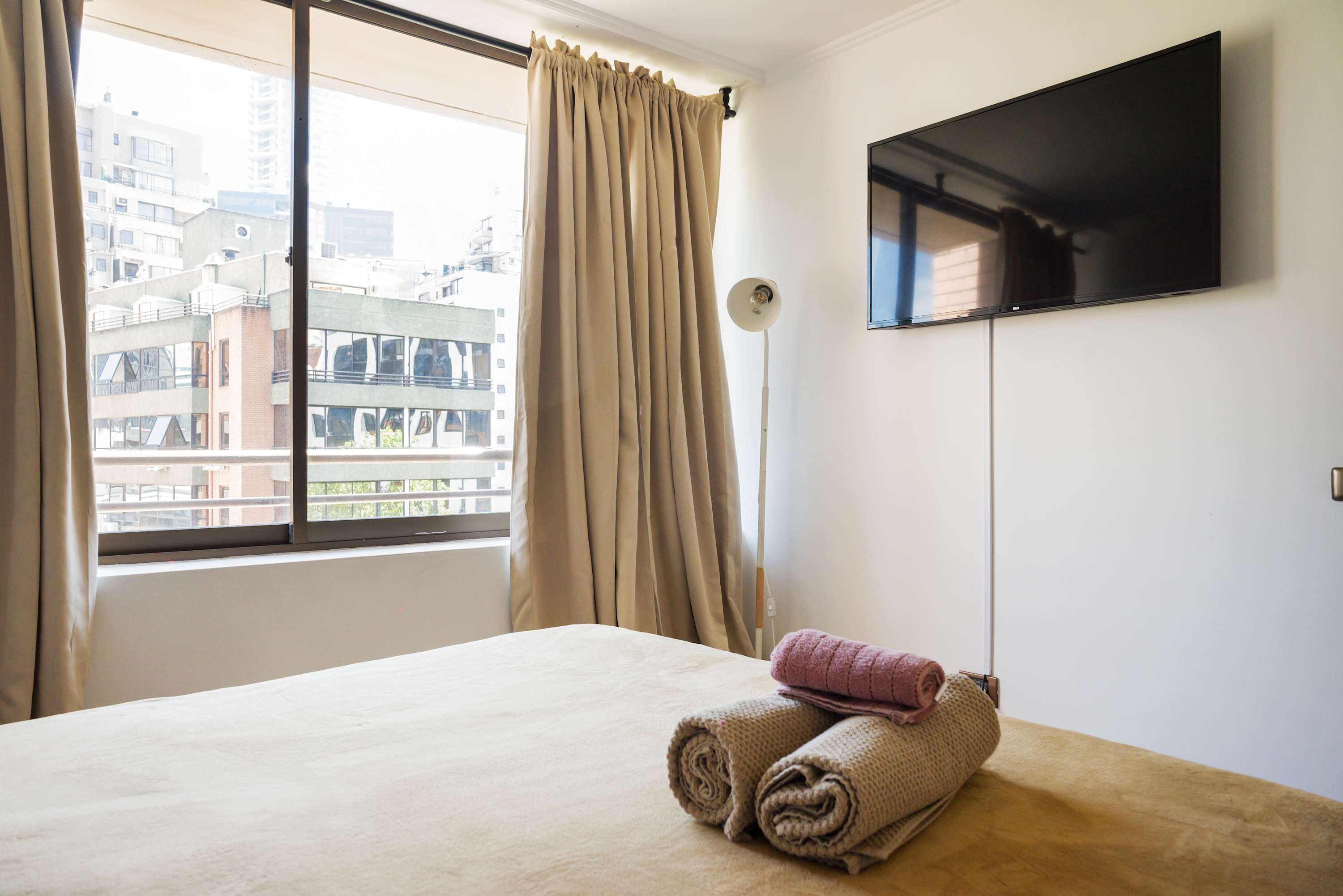 Relax in this cozy bedroom with a stunning city view and modern amenities, perfect for unwinding after a day of exploring.