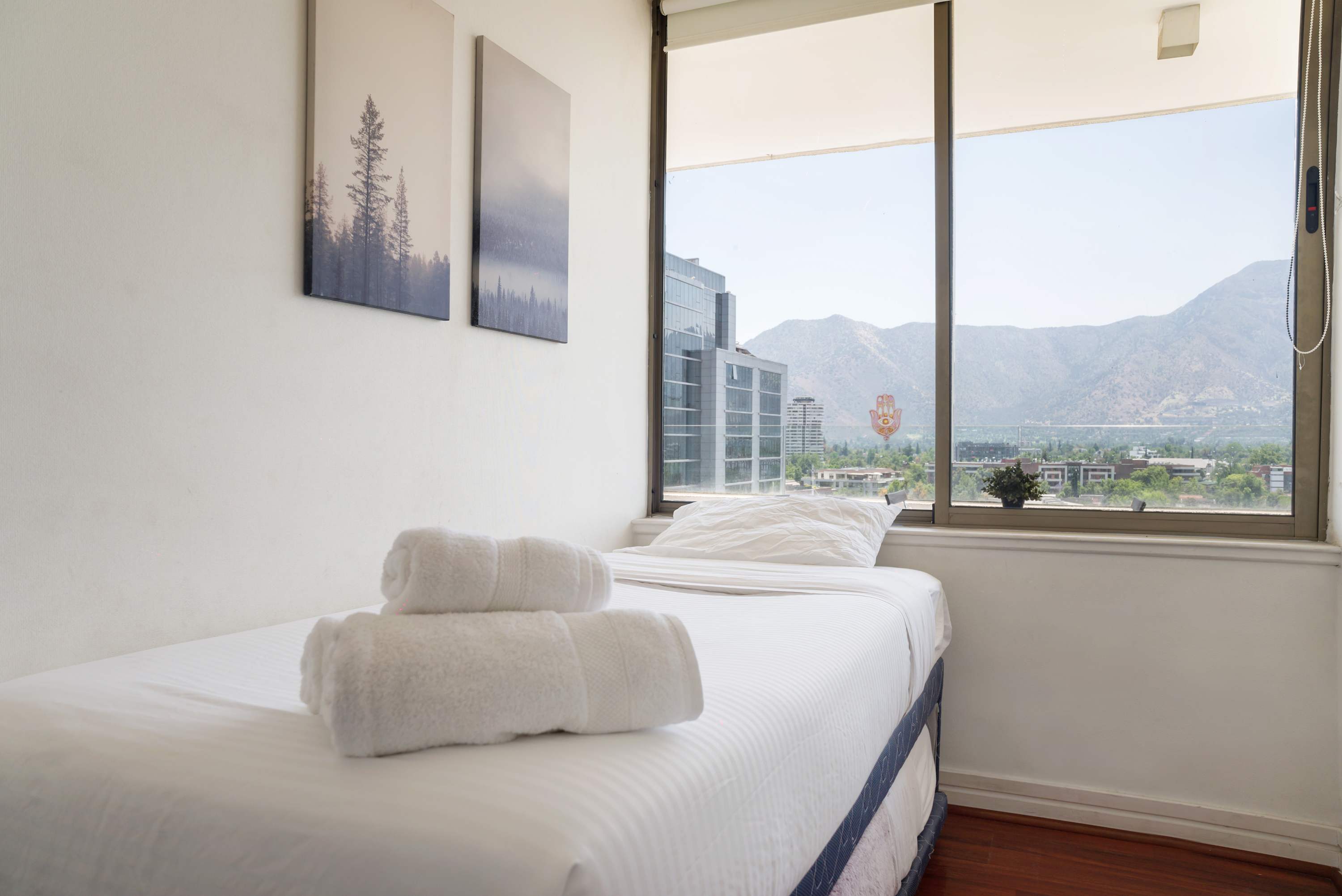 Cozy bedroom with stunning mountain and city views, perfect for relaxation and unwinding.