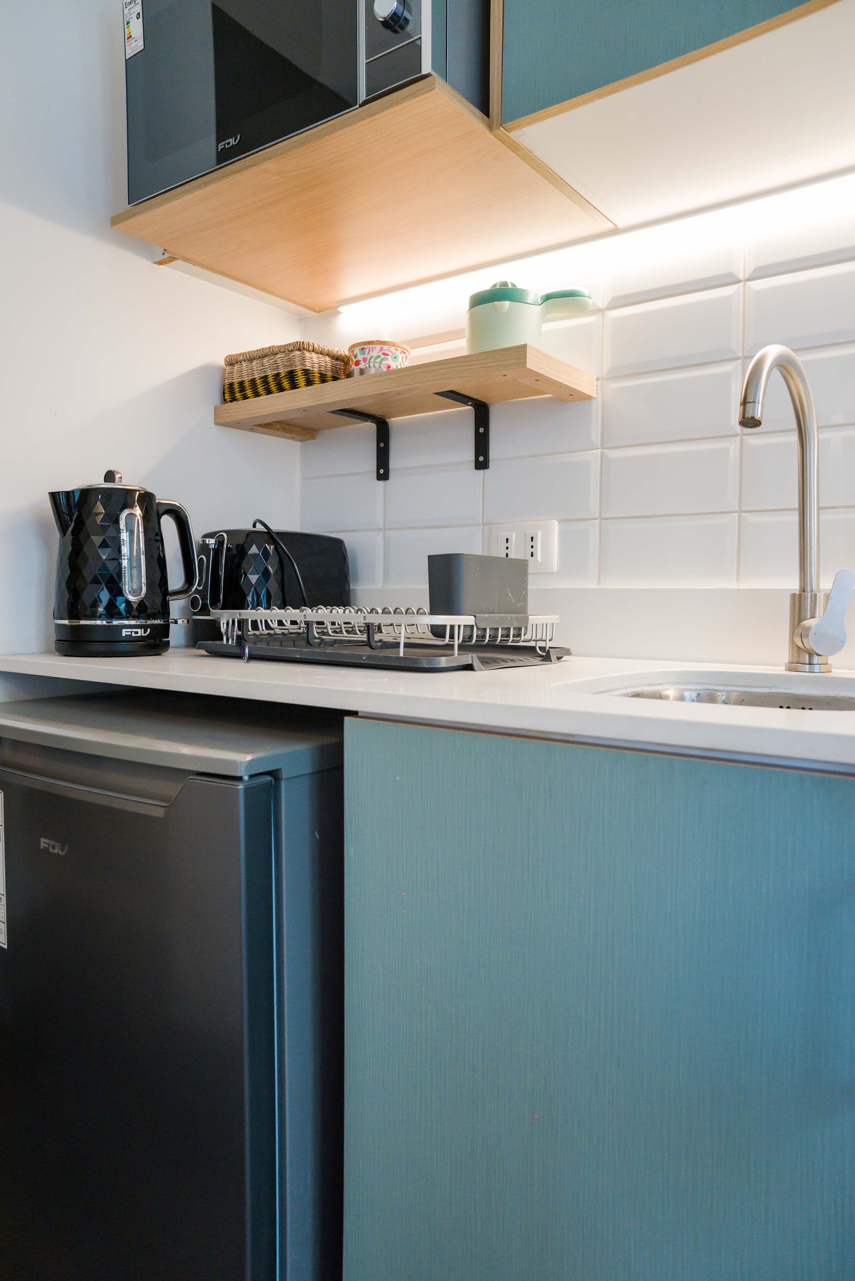 Modern and efficient kitchenette with essential appliances for a cozy stay.