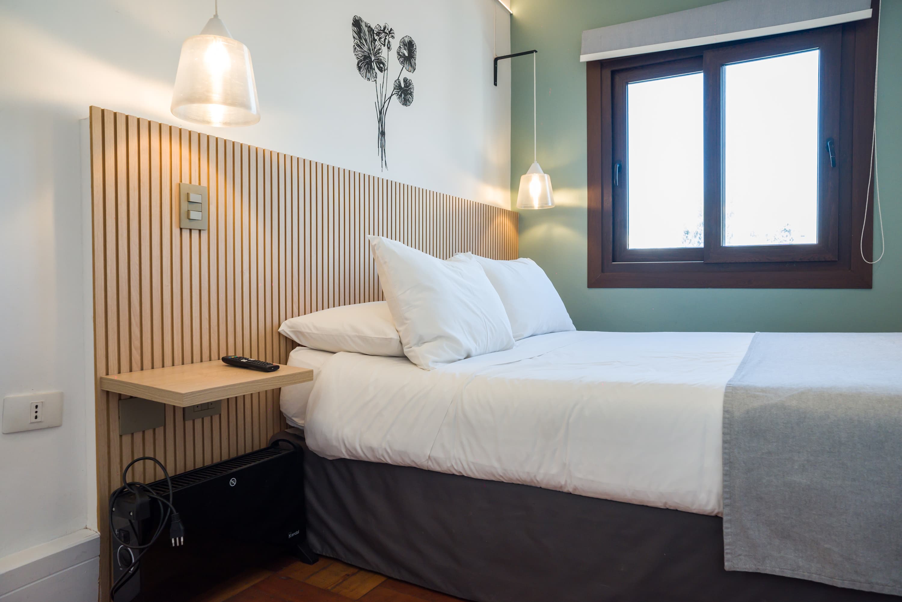 Relax in this cozy bedroom with modern decor and natural light, perfect for a restful stay.