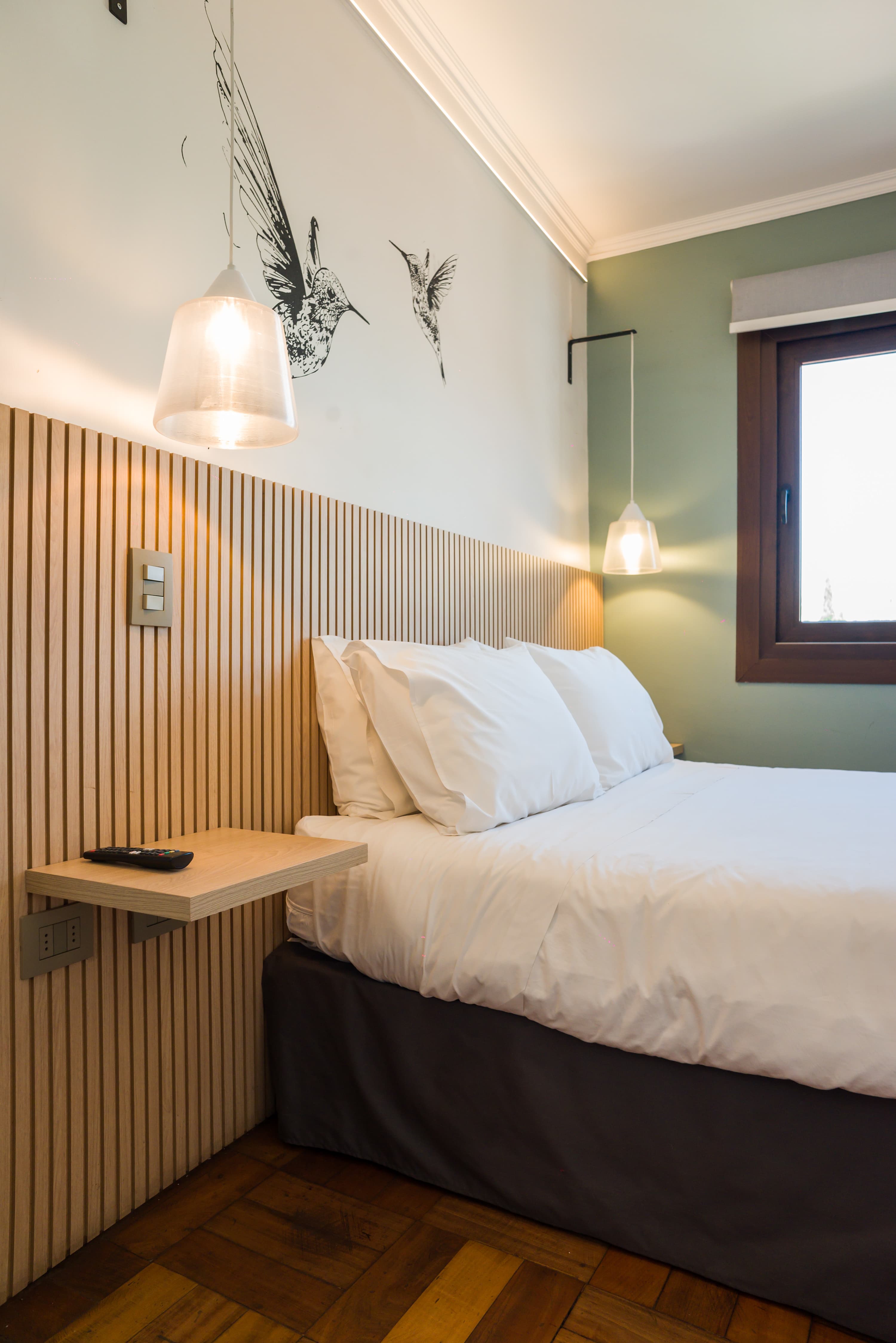 Relax in this cozy bedroom with stylish decor and natural light, perfect for a restful stay.