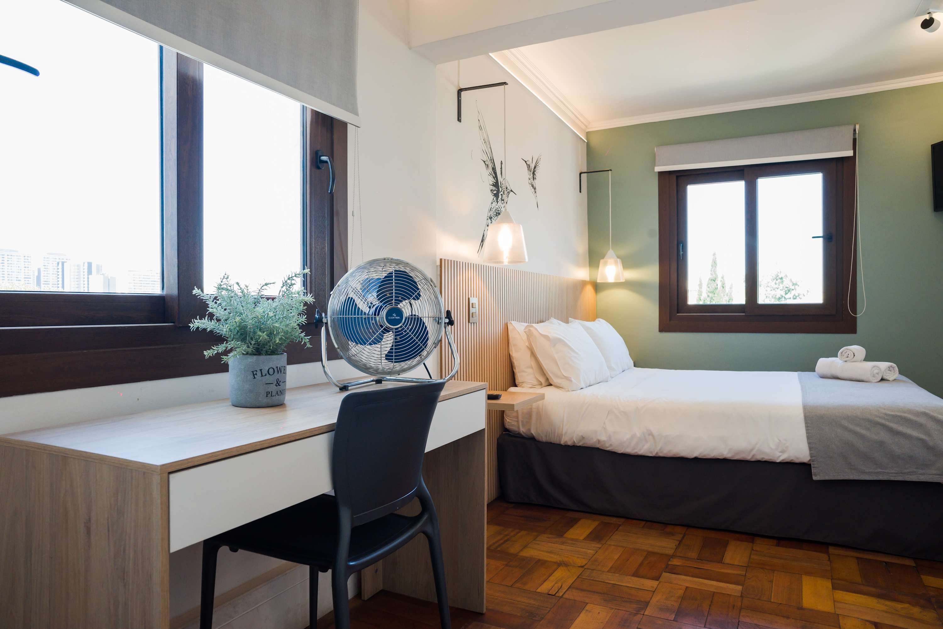 Bright and cozy studio with a comfortable bed, work desk, and lovely city views, perfect for a relaxing stay.