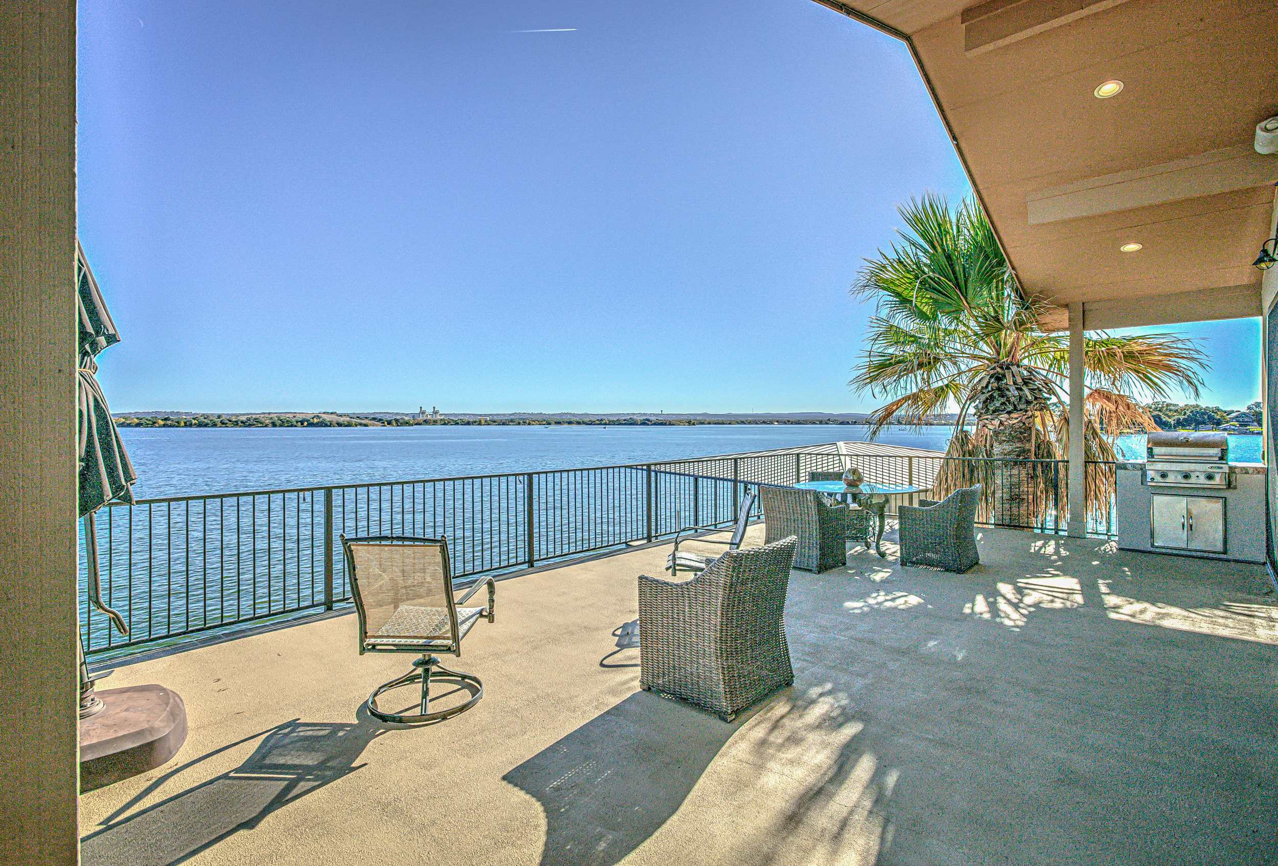 Upper level patio w/BBQ grill, outdoor seating, & panoramic lake views