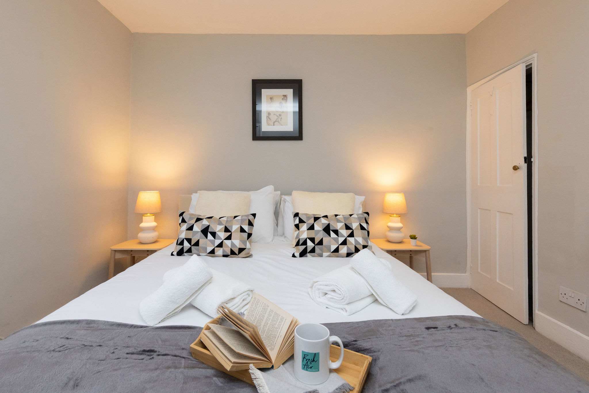 Bedside table with side lamps accompany this room perfectly.