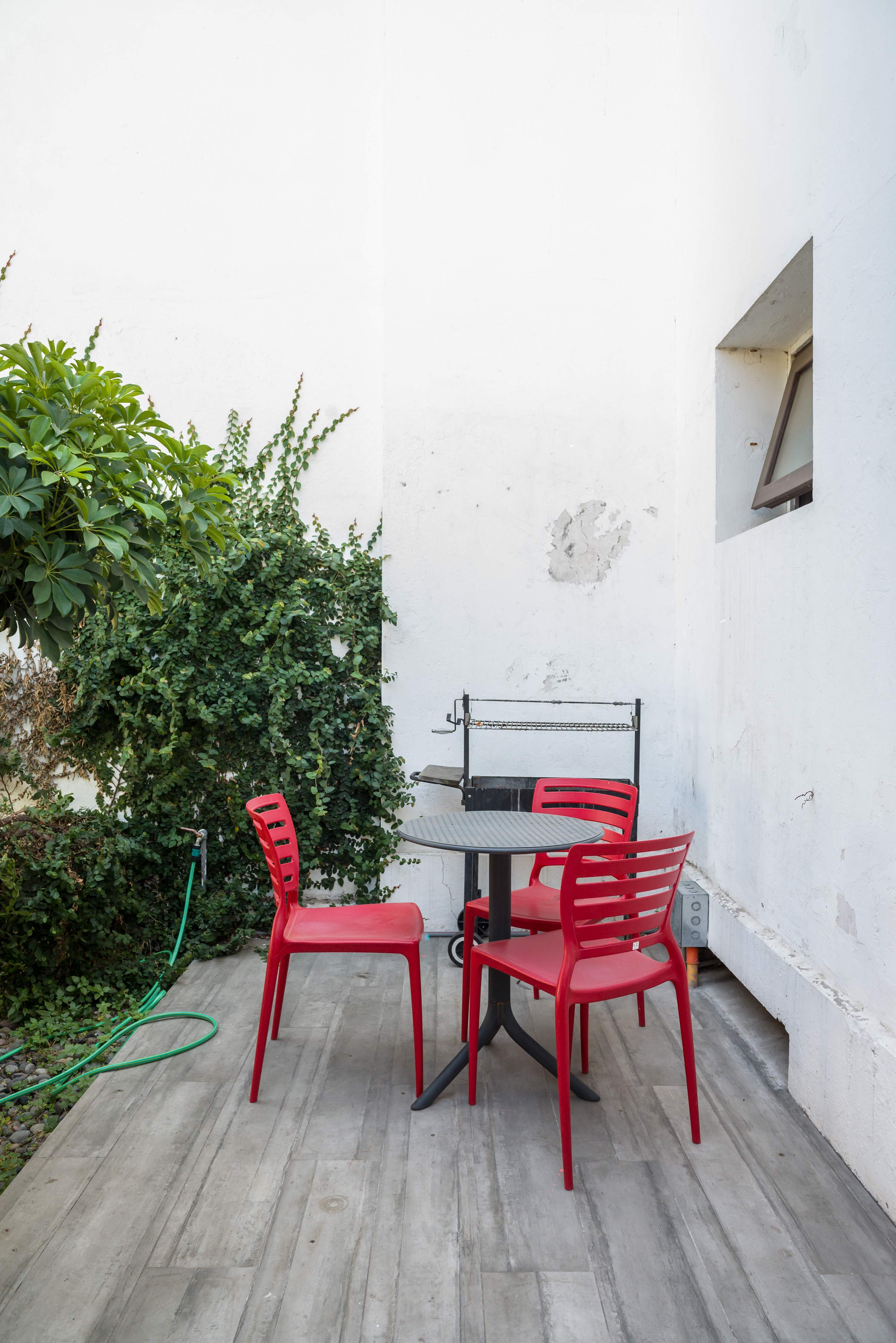 Charming private patio with seating and BBQ grill, perfect for outdoor dining and relaxation.