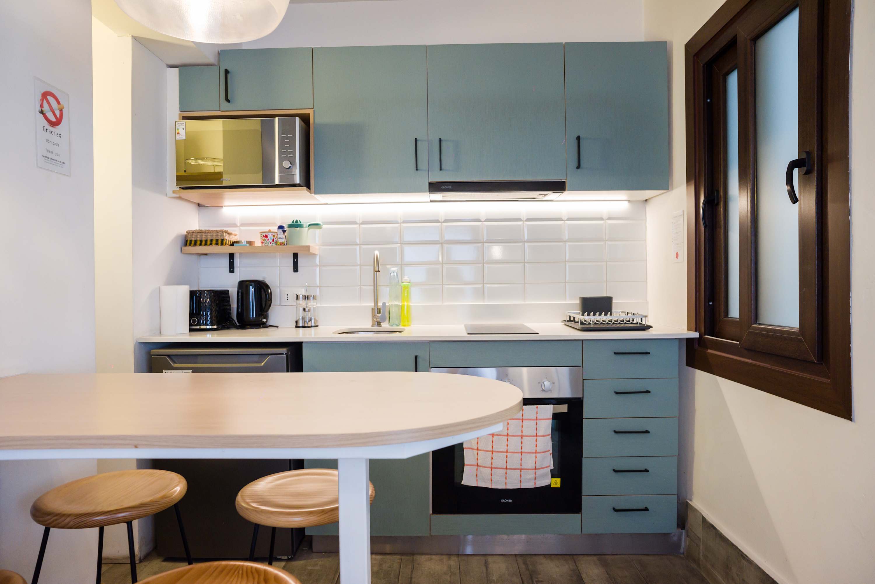 Modern and fully equipped kitchen with stylish teal cabinetry and breakfast bar, perfect for cozy meals.