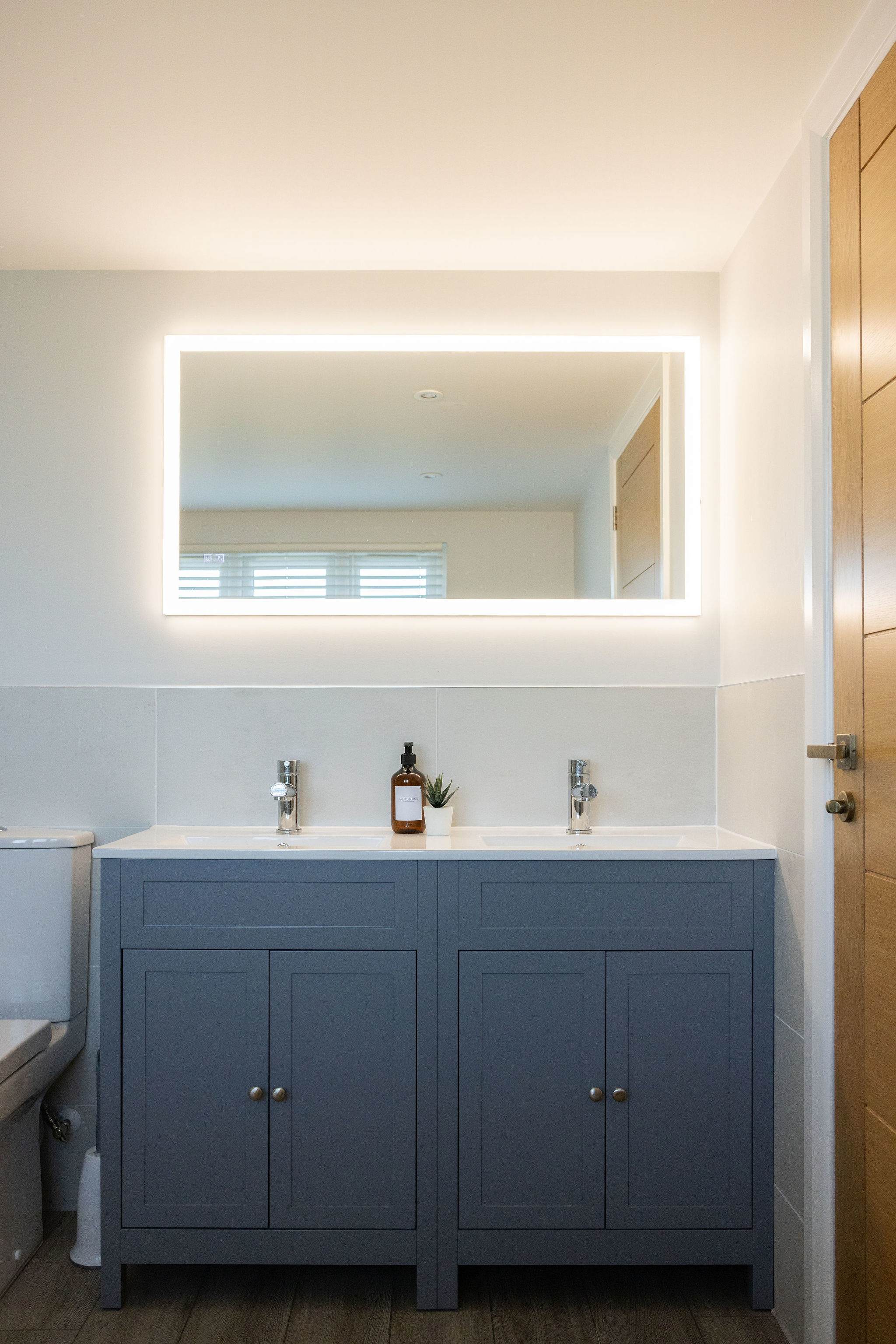 His and hers sinks with a large overhead led mirror
