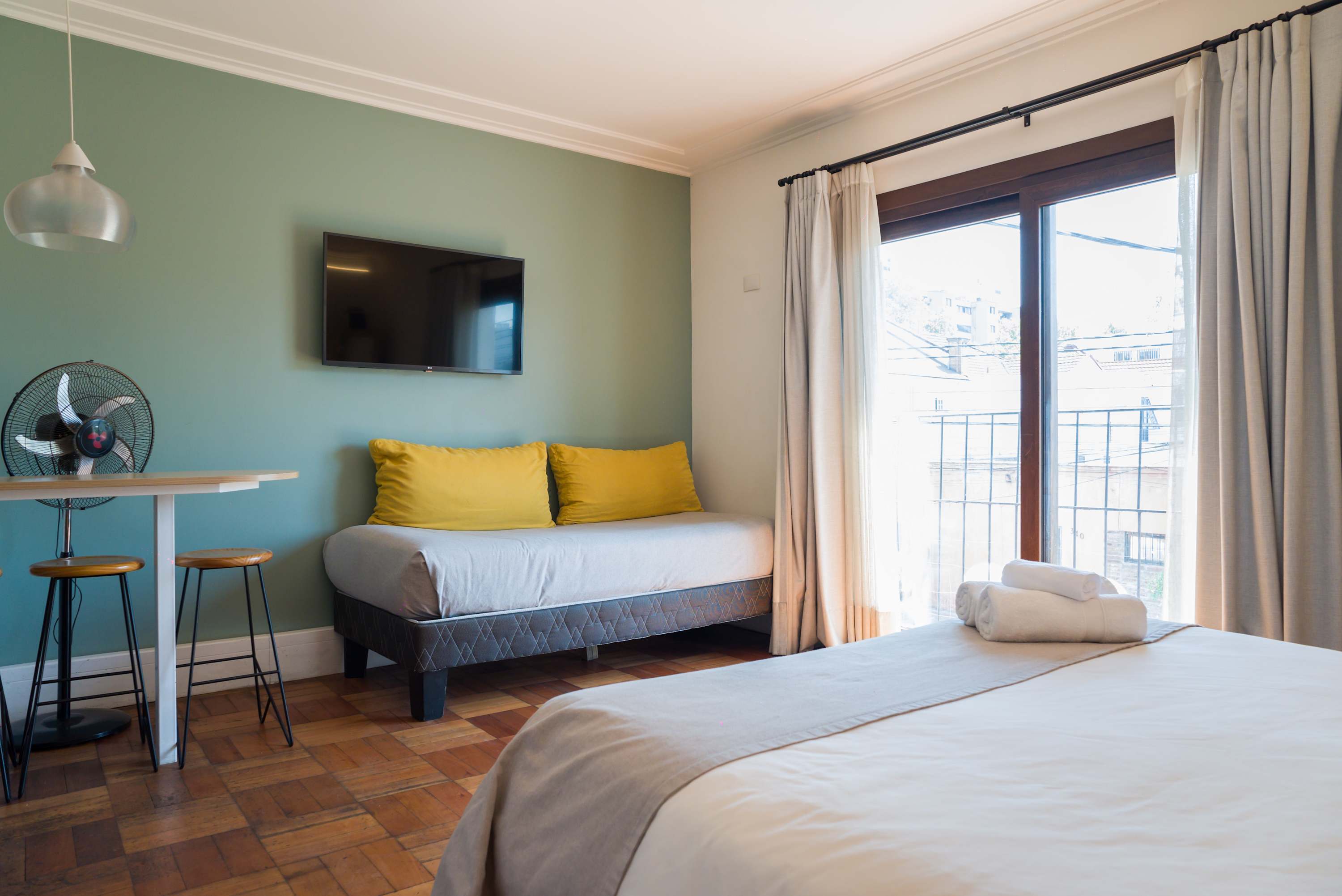 Cozy studio with natural light, a comfy daybed, and a relaxing ambiance perfect for a getaway.