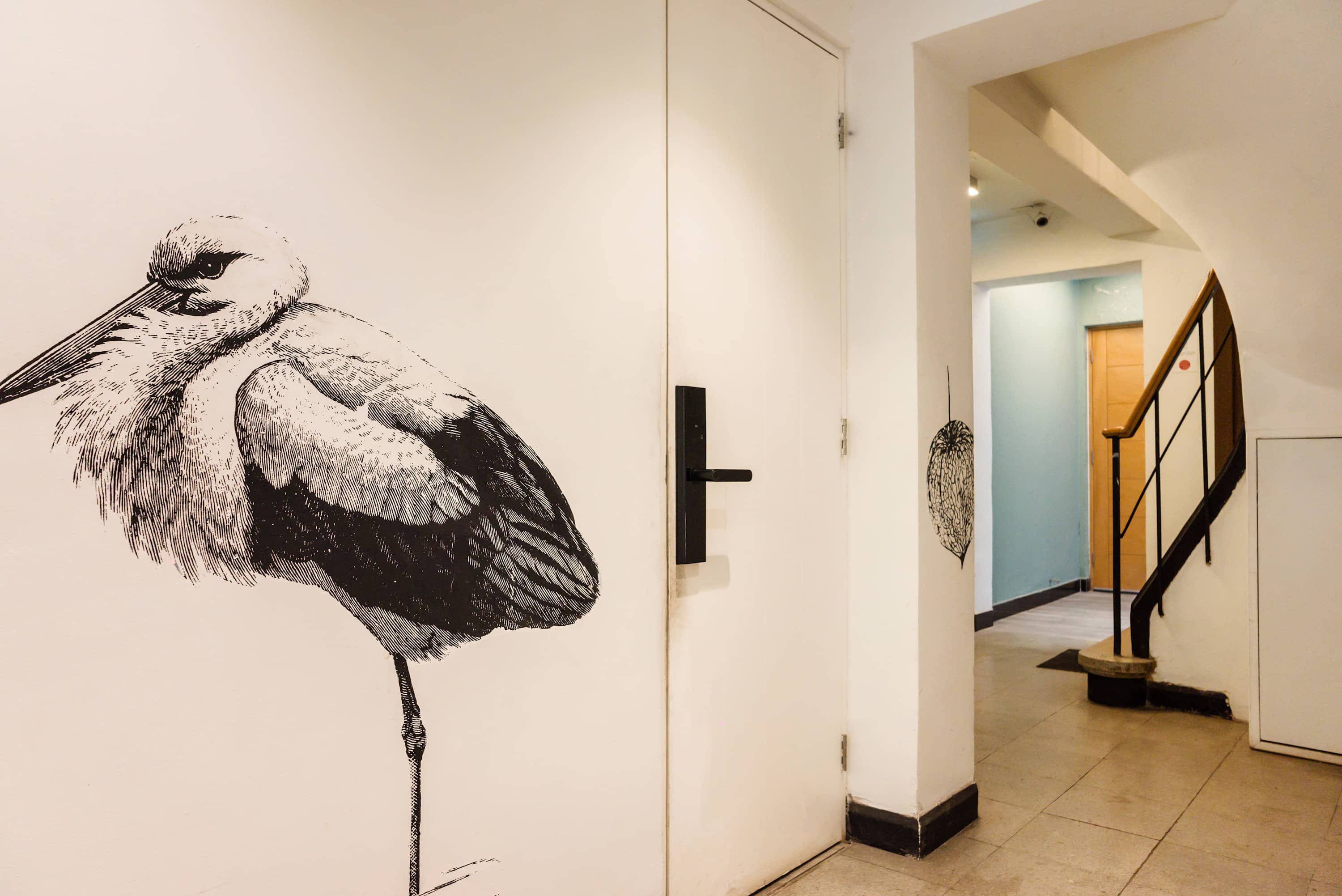 Artistic hallway with unique bird mural, offering a creative touch to your stay.