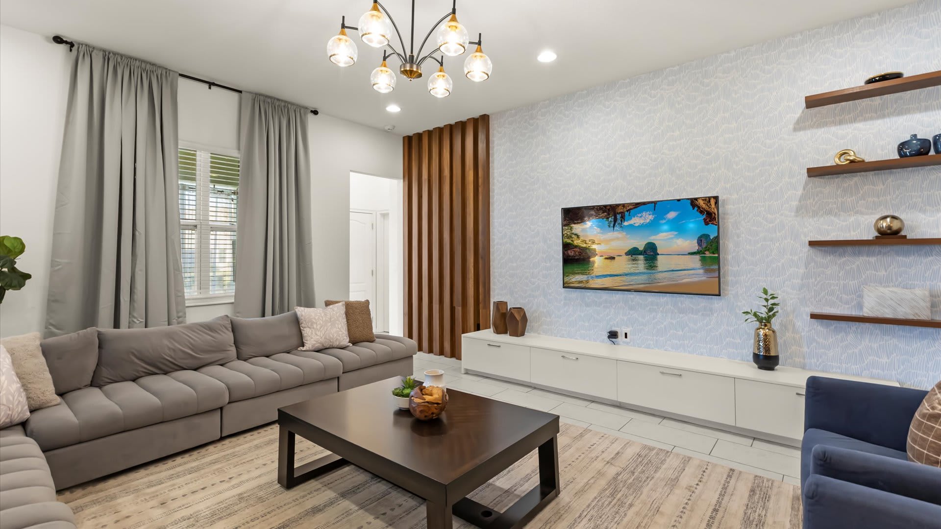 Contemporary living room with large TV and tasteful artwork.