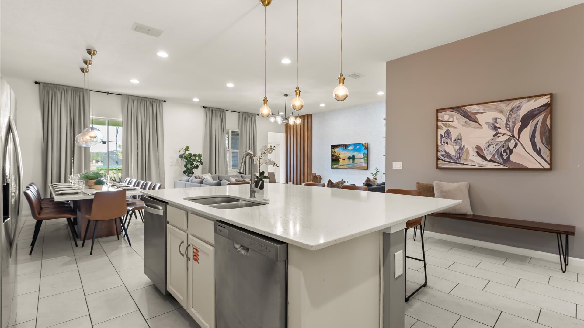 Sleek white kitchen with island seating and stainless appliances.