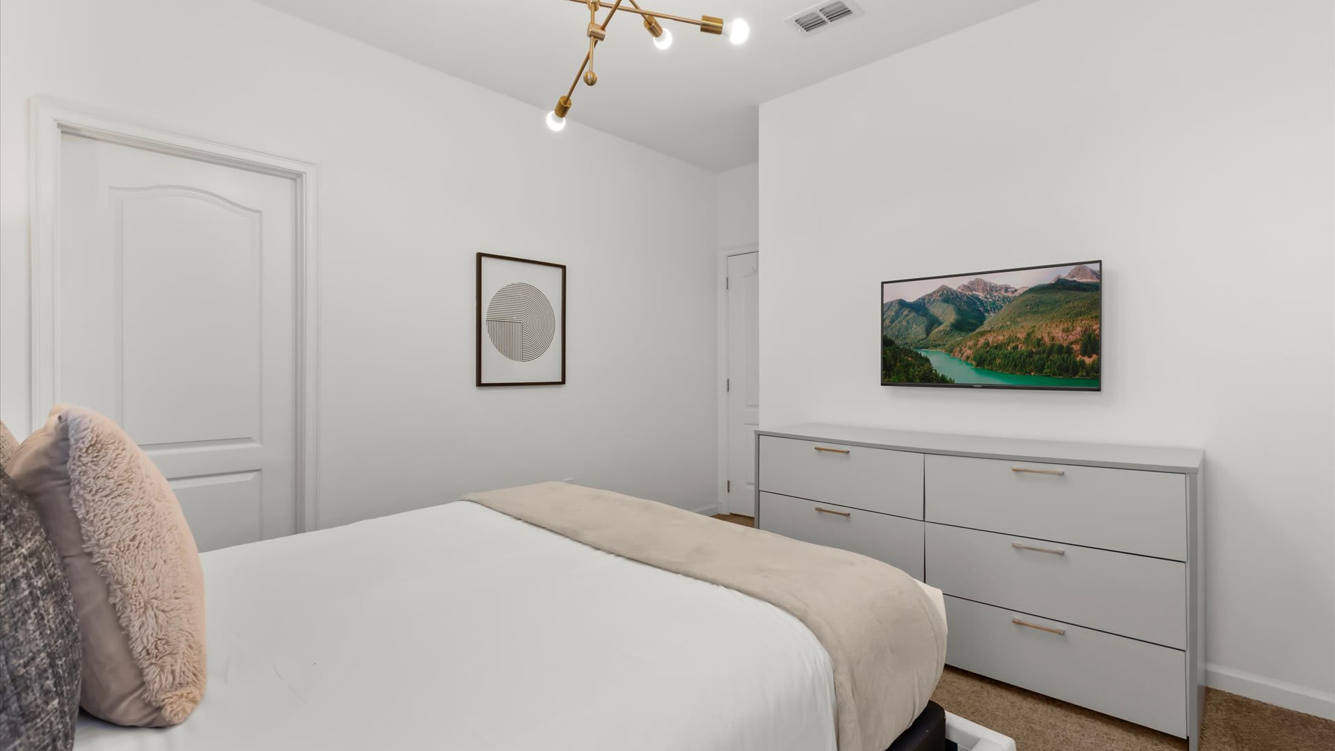 Stylish queen bedroom featuring warm lighting and a modern design.