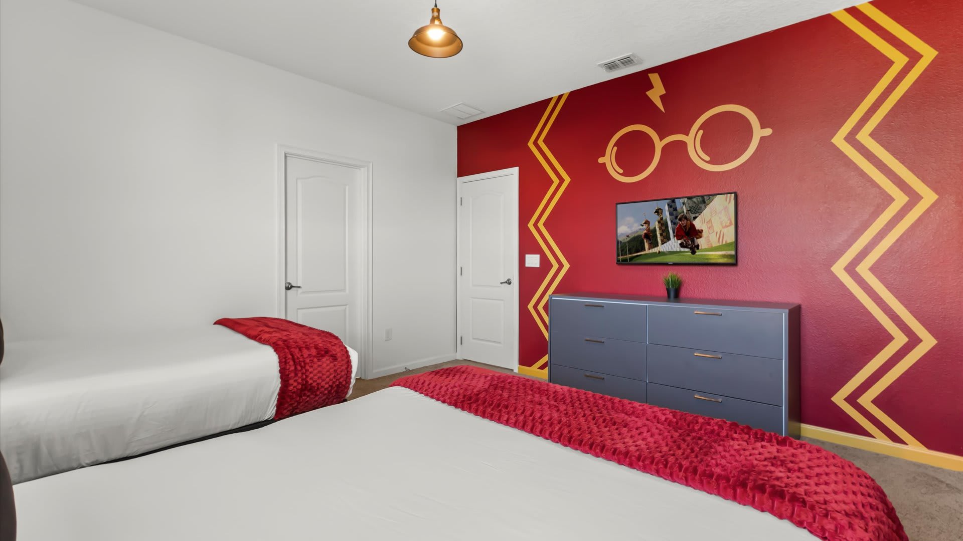 Vibrant themed twin room with bold red accent wall.